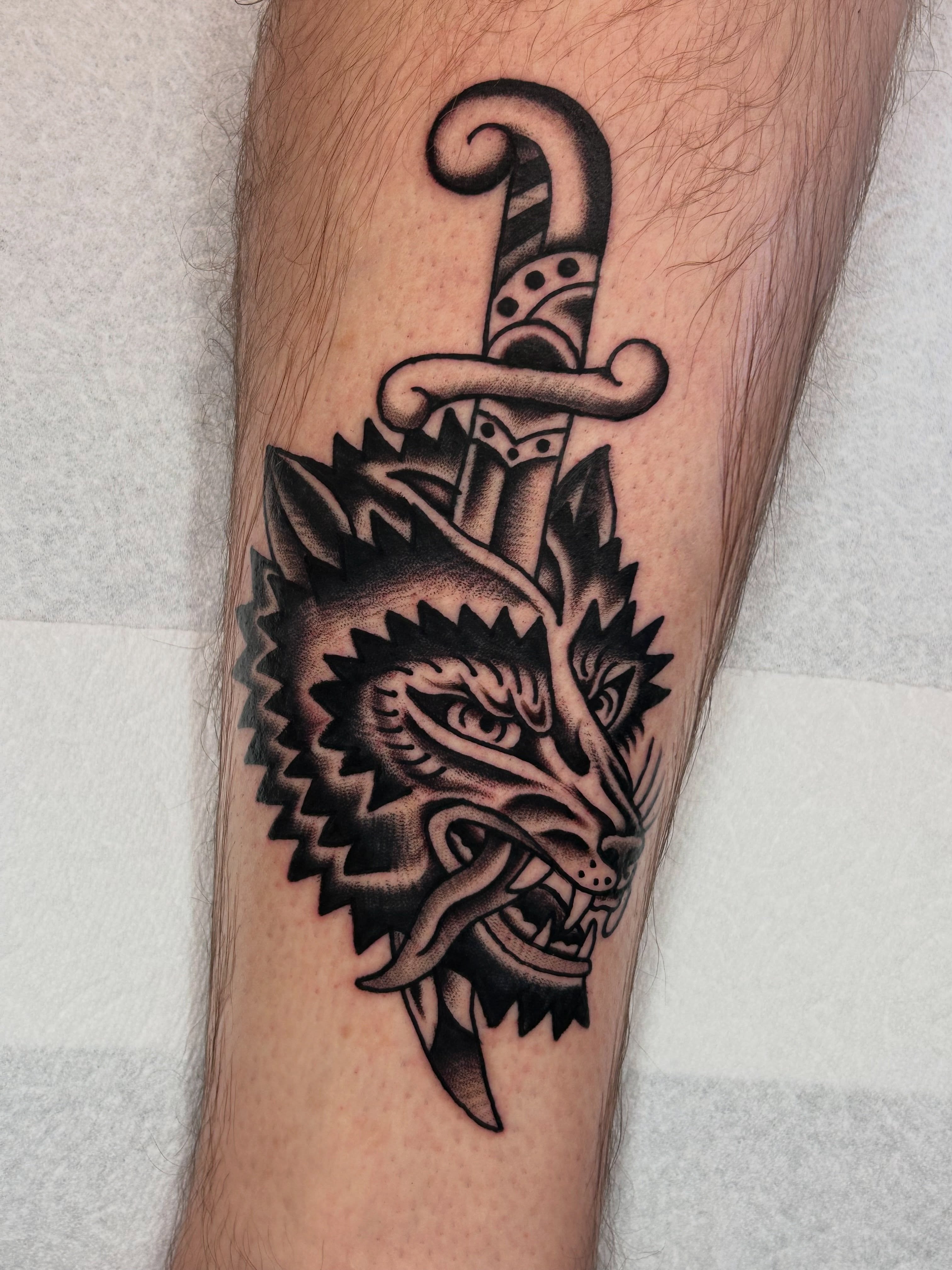 Wolf head with sword American traditional tattoo on the forearm by β π€ππ©π¦π©π’π β± β