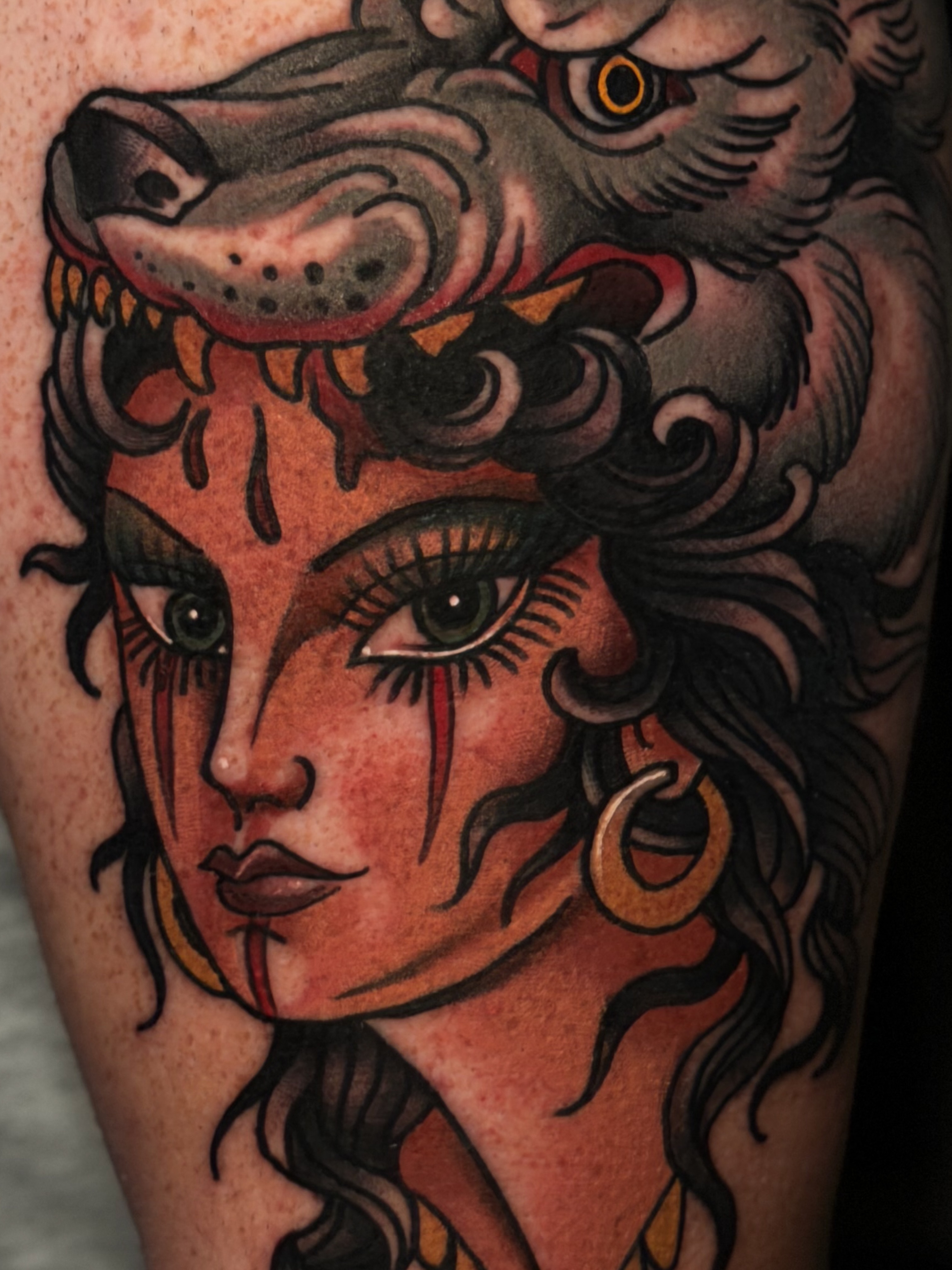 Woman with wolf head American traditional tattoo on the forearm by Cory Cartwright