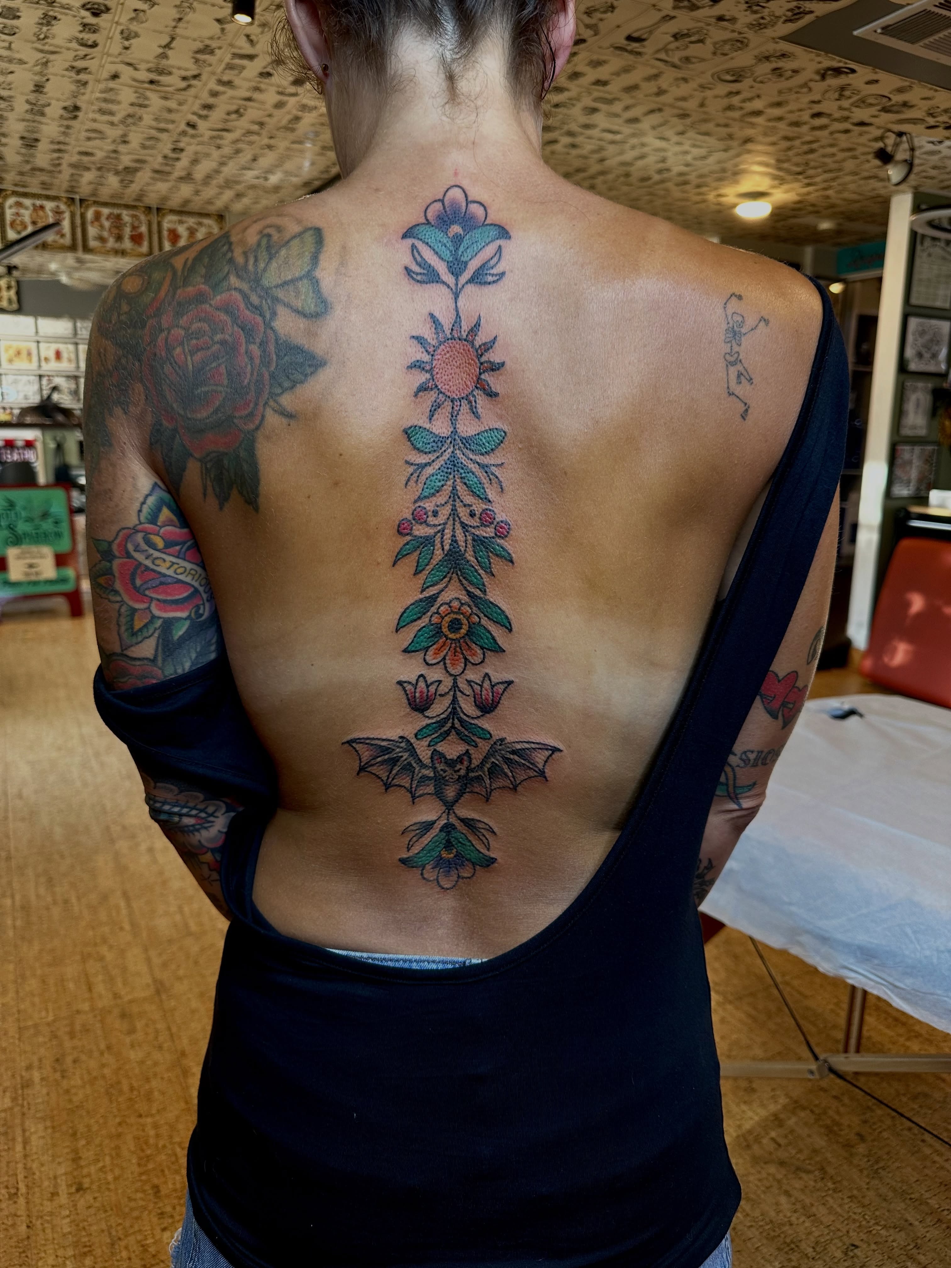 Floral spine neo-traditional tattoo by teddy, Portland, Oregon