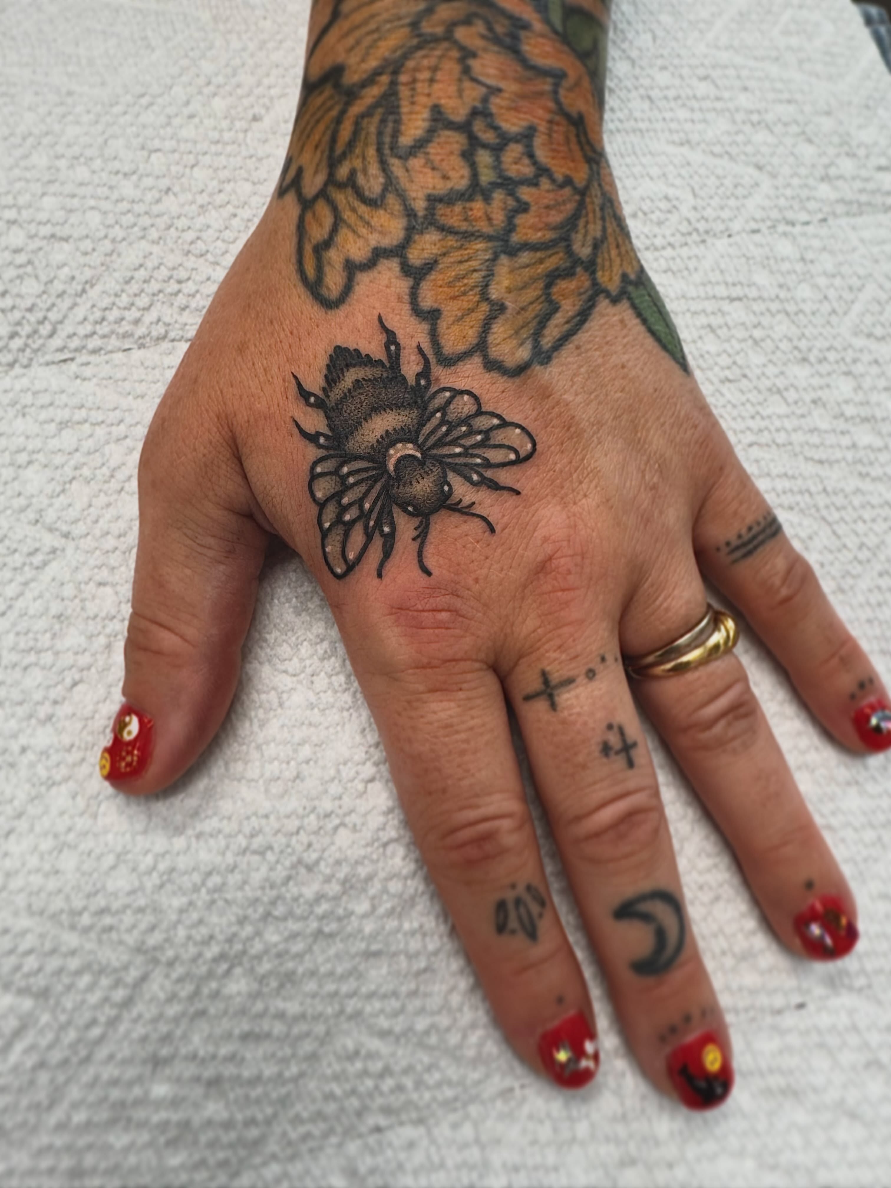 Bee black and grey tattoo on the hand by Stefany