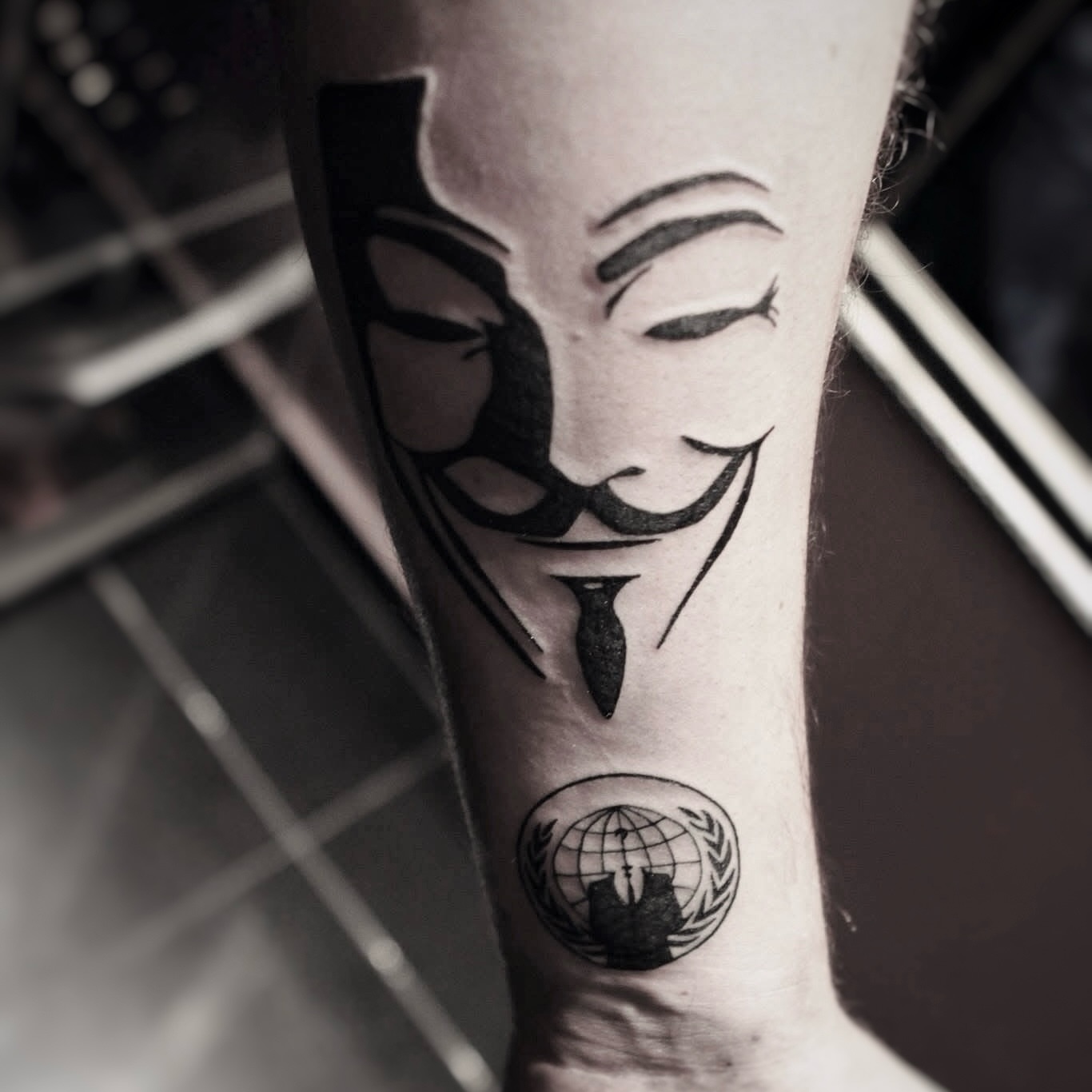 V for vendetta mask black and grey tattoo on the forearm by Yana Aizen