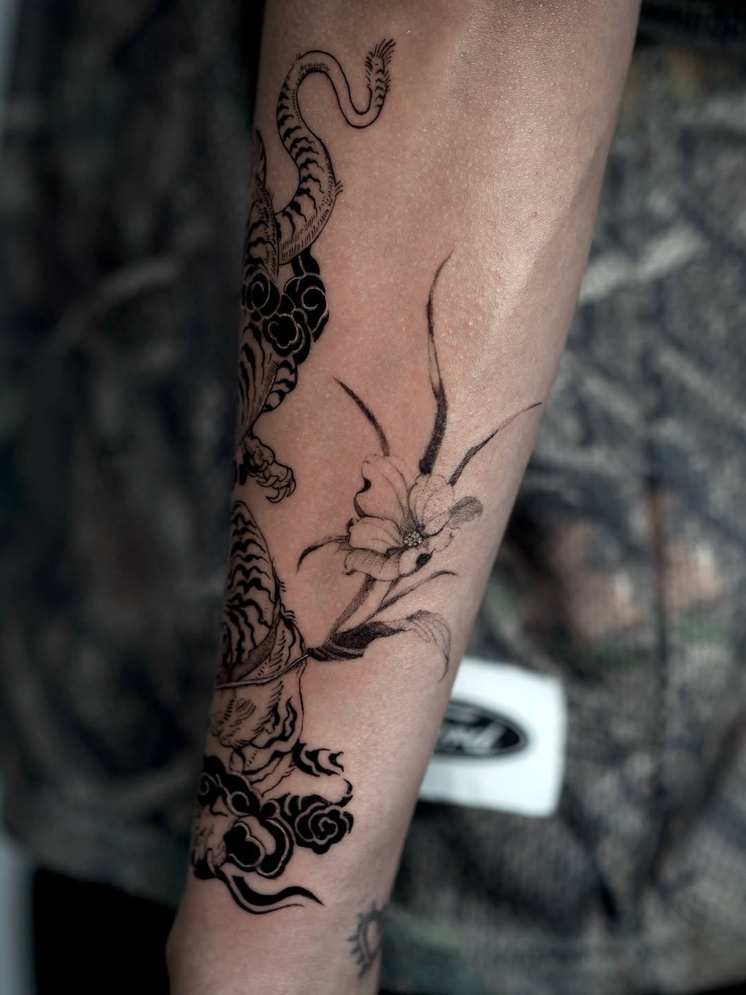 Tiger and flower Japanese tattoo on the forearm by Sara