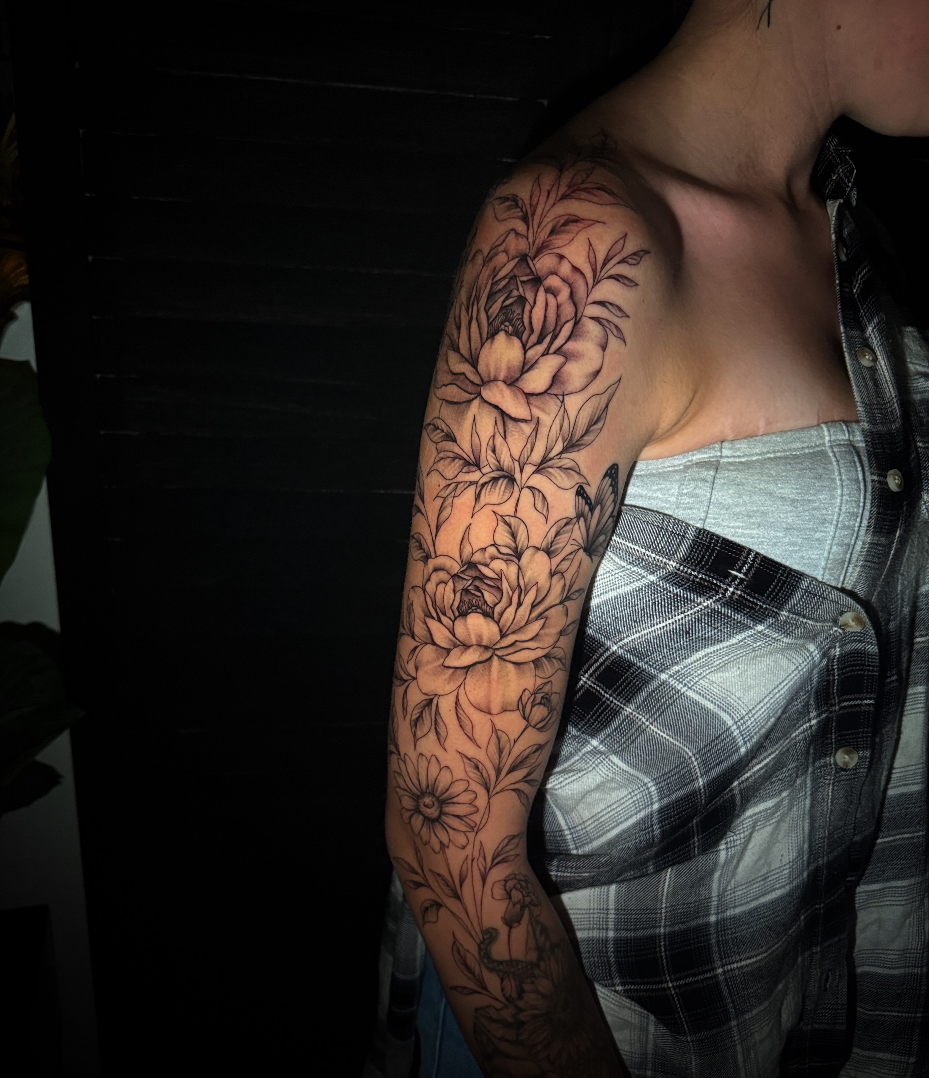 Floral bouquet black and grey tattoo on the upper arm by Sad Girl Tattoos