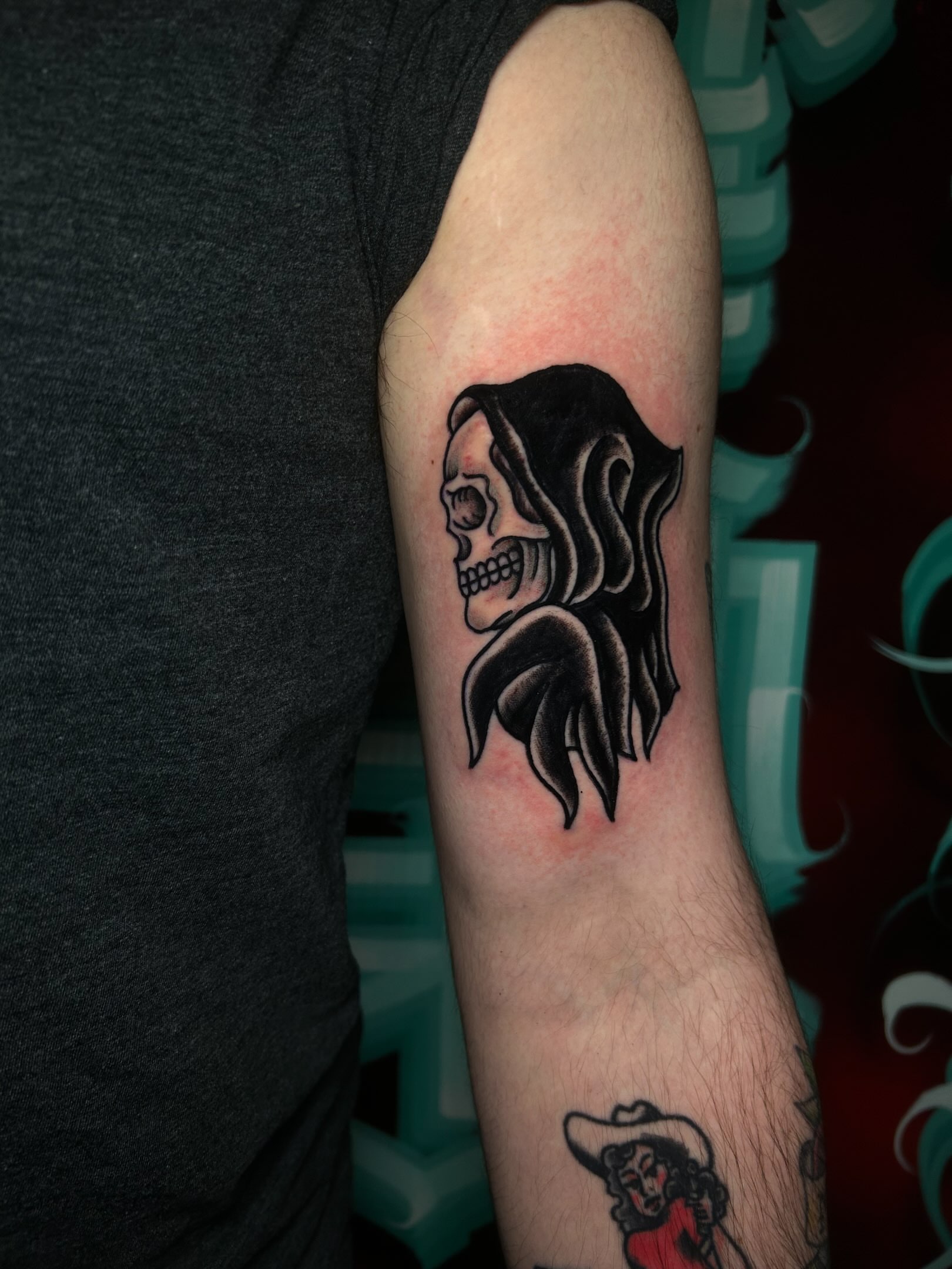 Skull with flowing hair black and grey tattoo on the forearm by Alycia