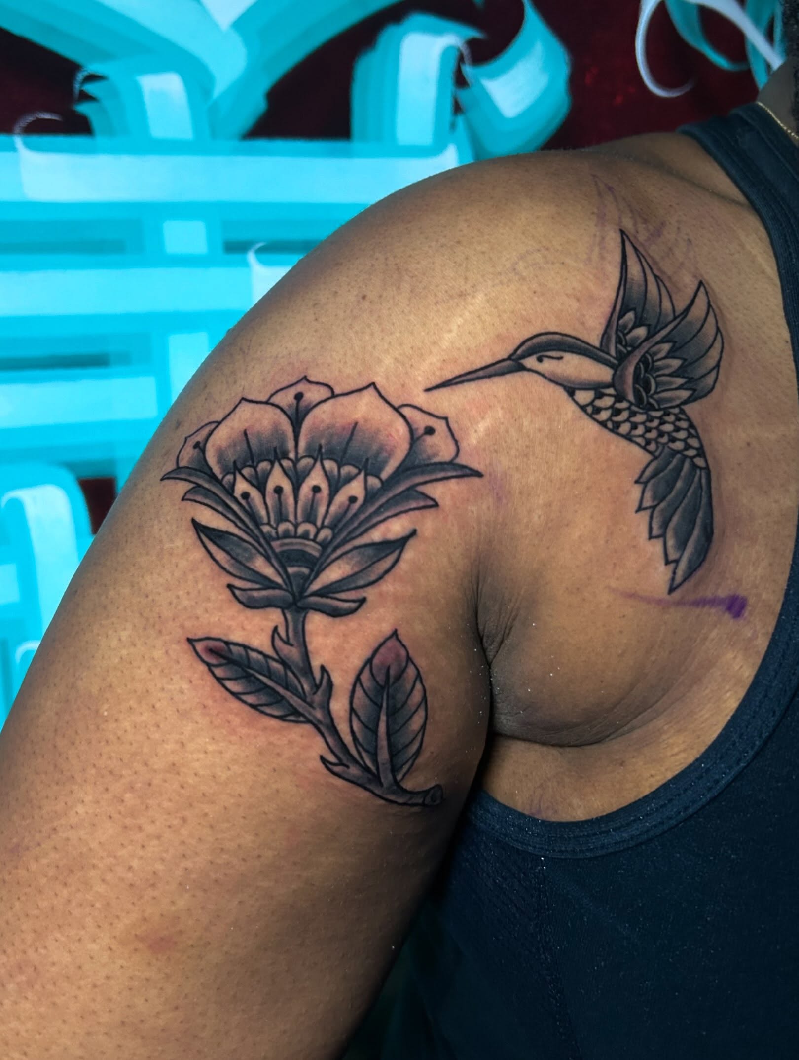Hummingbird and flower black and grey tattoo on the shoulder by Alycia