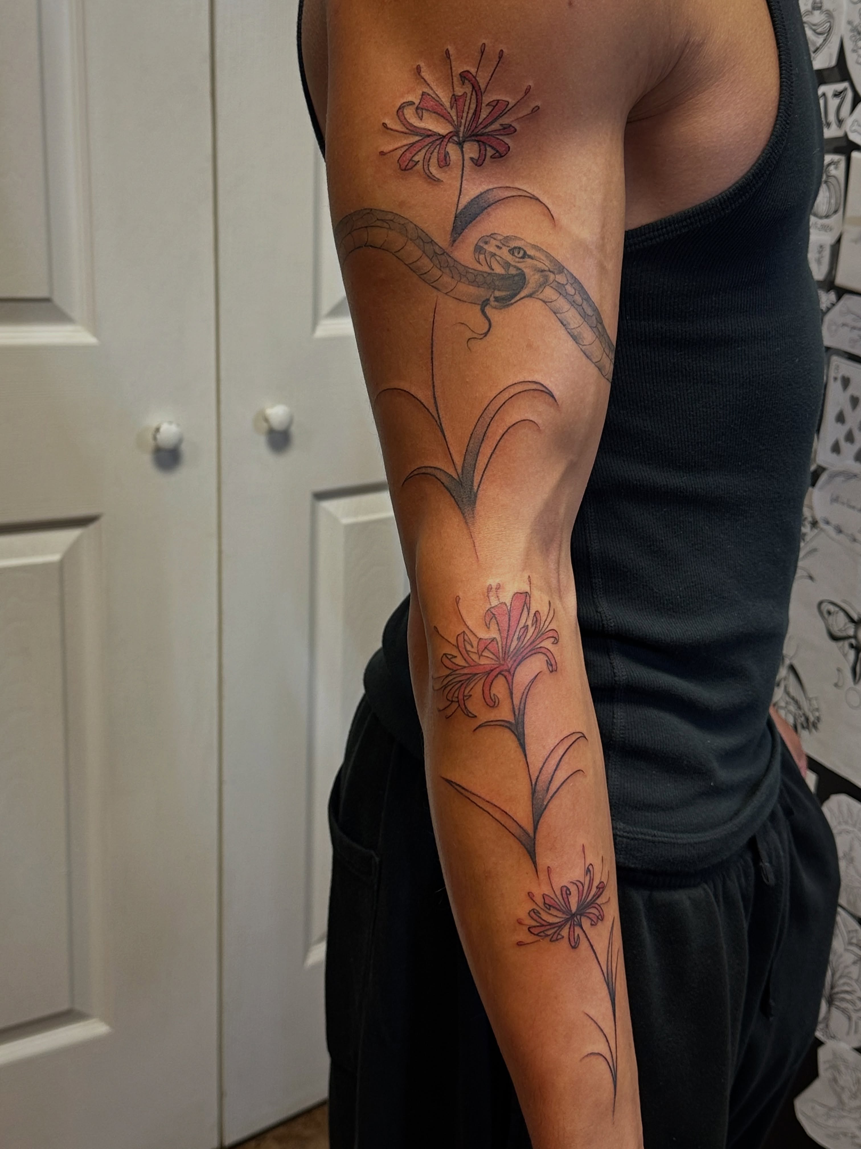 Snake and flowers realism tattoo on the forearm by Jocelyn