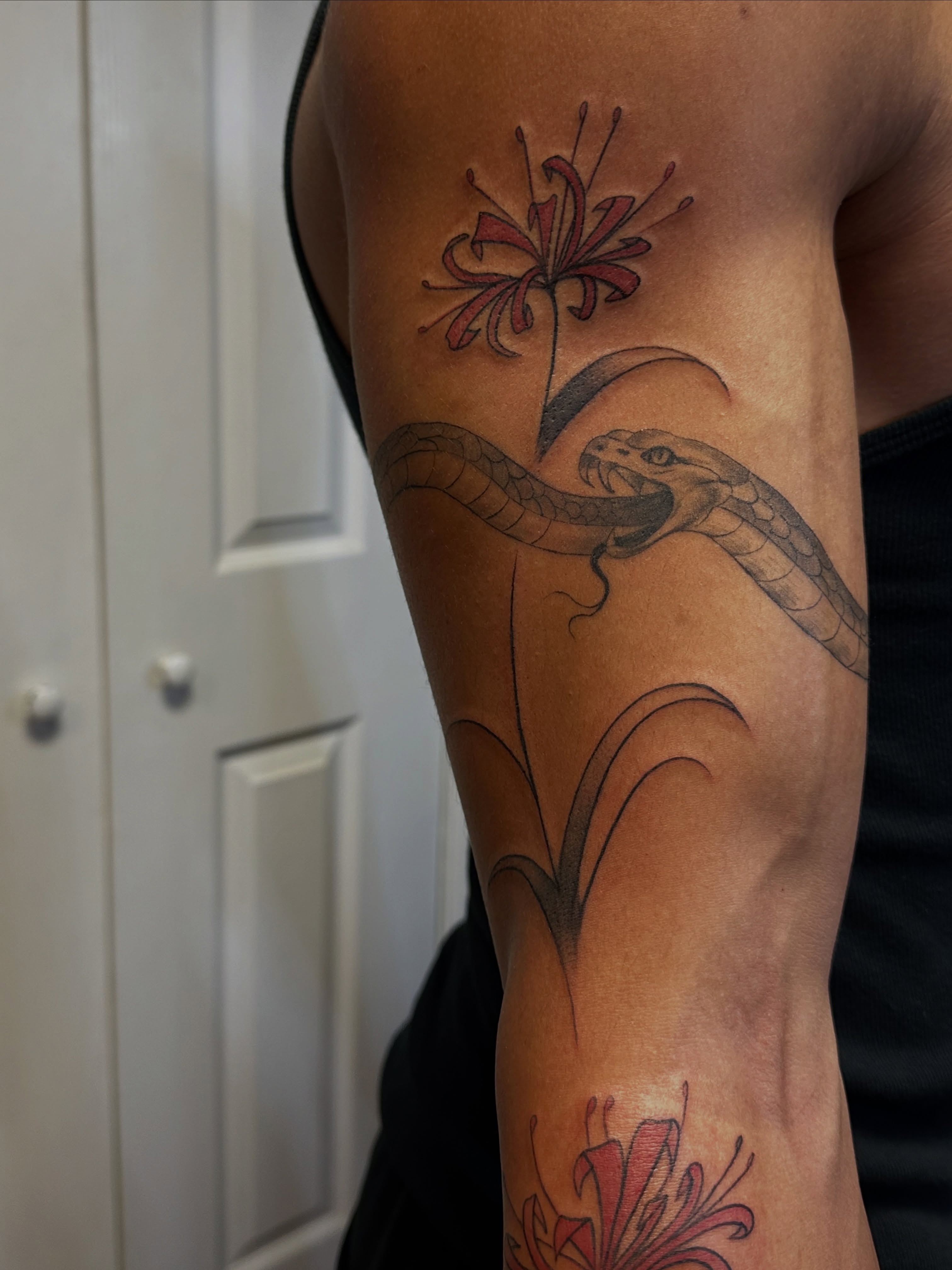 Snake and flower black and grey tattoo on the forearm by Jocelyn