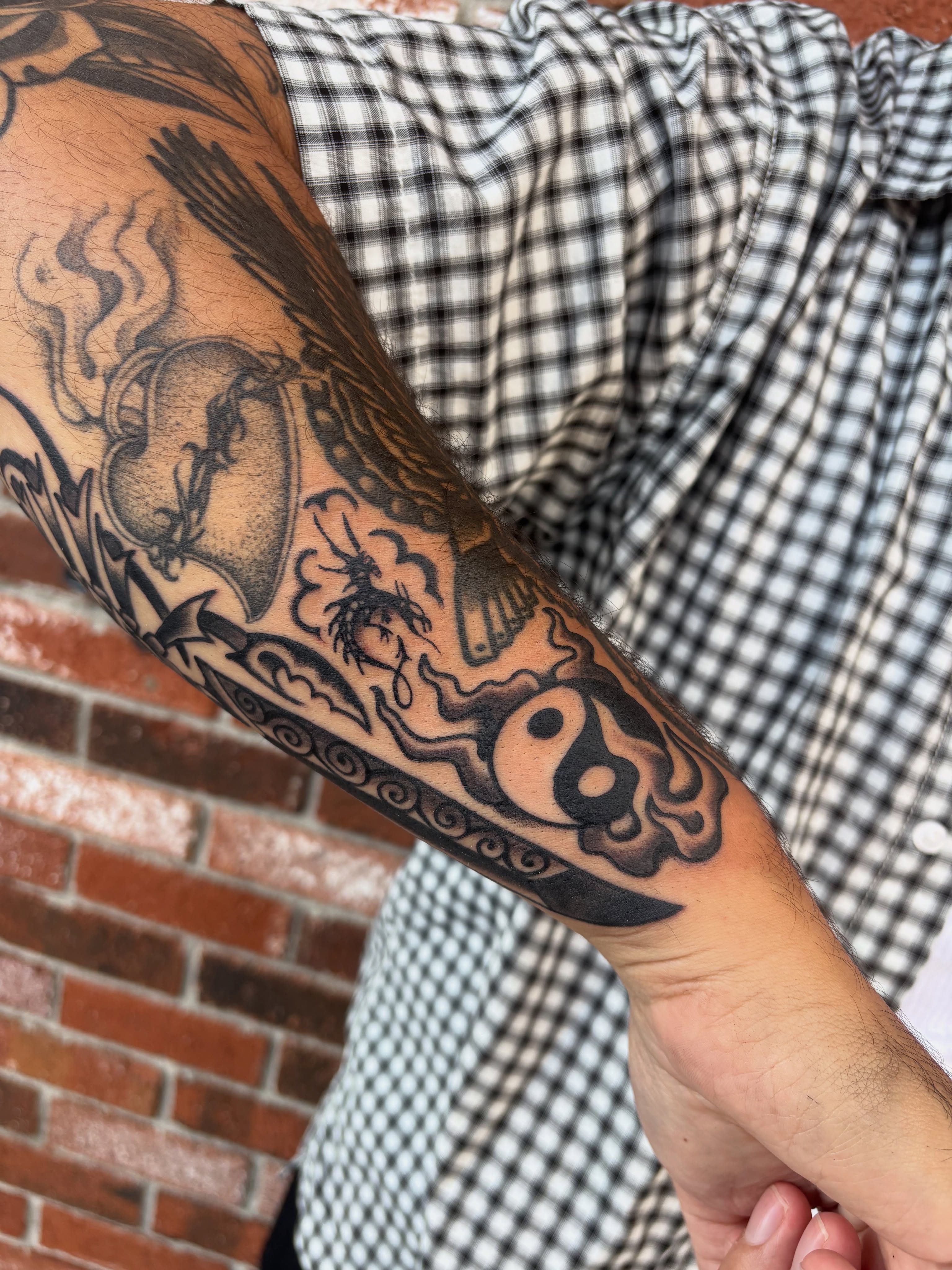 Yin-yang symbol black and grey tattoo on the forearm by Andrew Silva