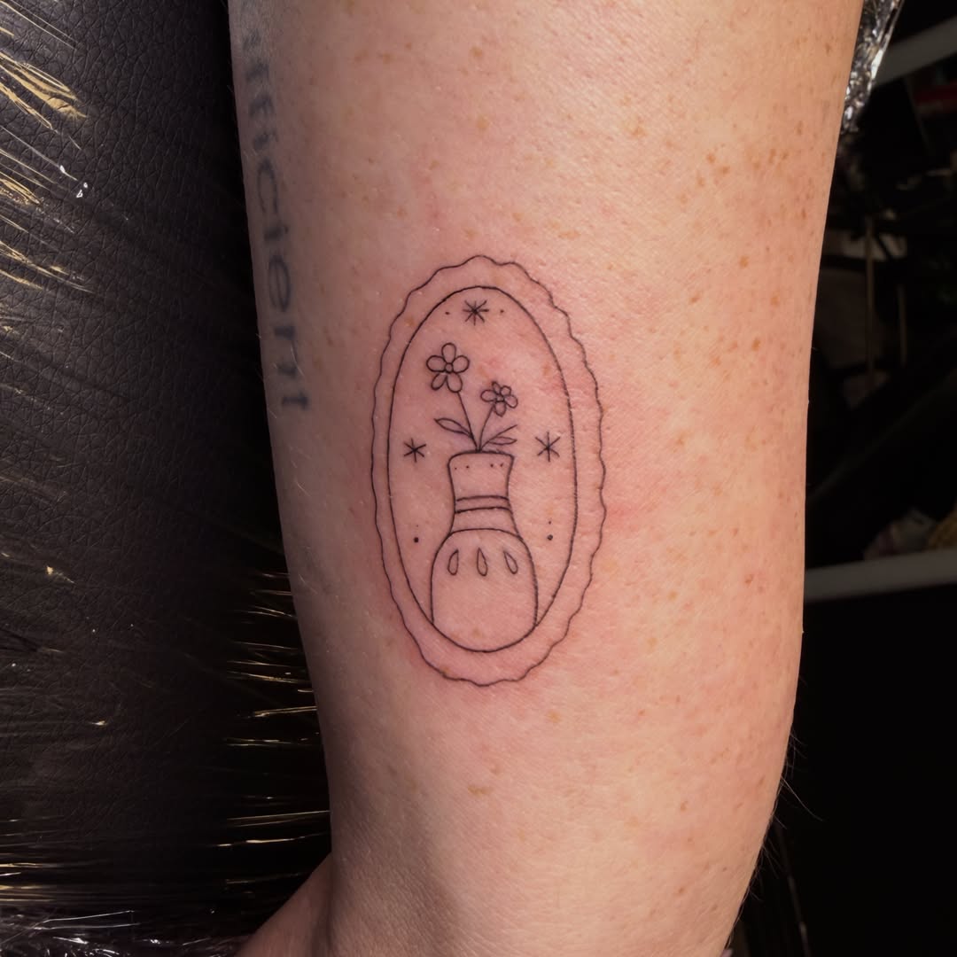 Vase with flowers fine line tattoo on the forearm by Pretty Ugly Tattoos