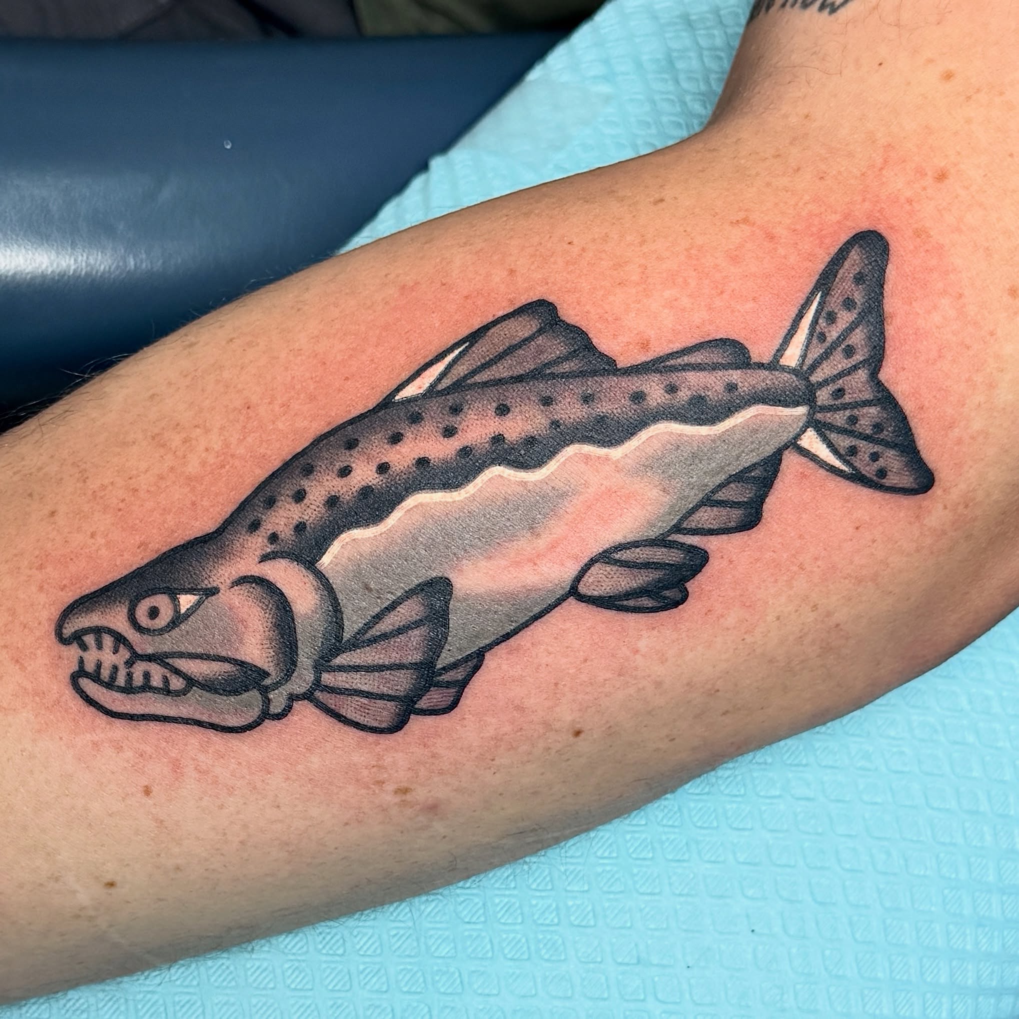Salmon black and grey tattoo on the forearm by Sam