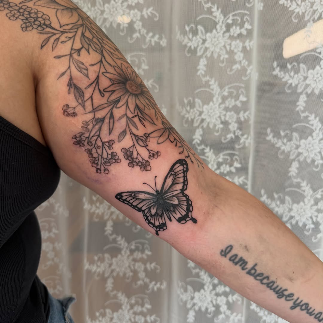 Butterfly and floral vine black and grey tattoo on the forearm by Lindsay Shriver