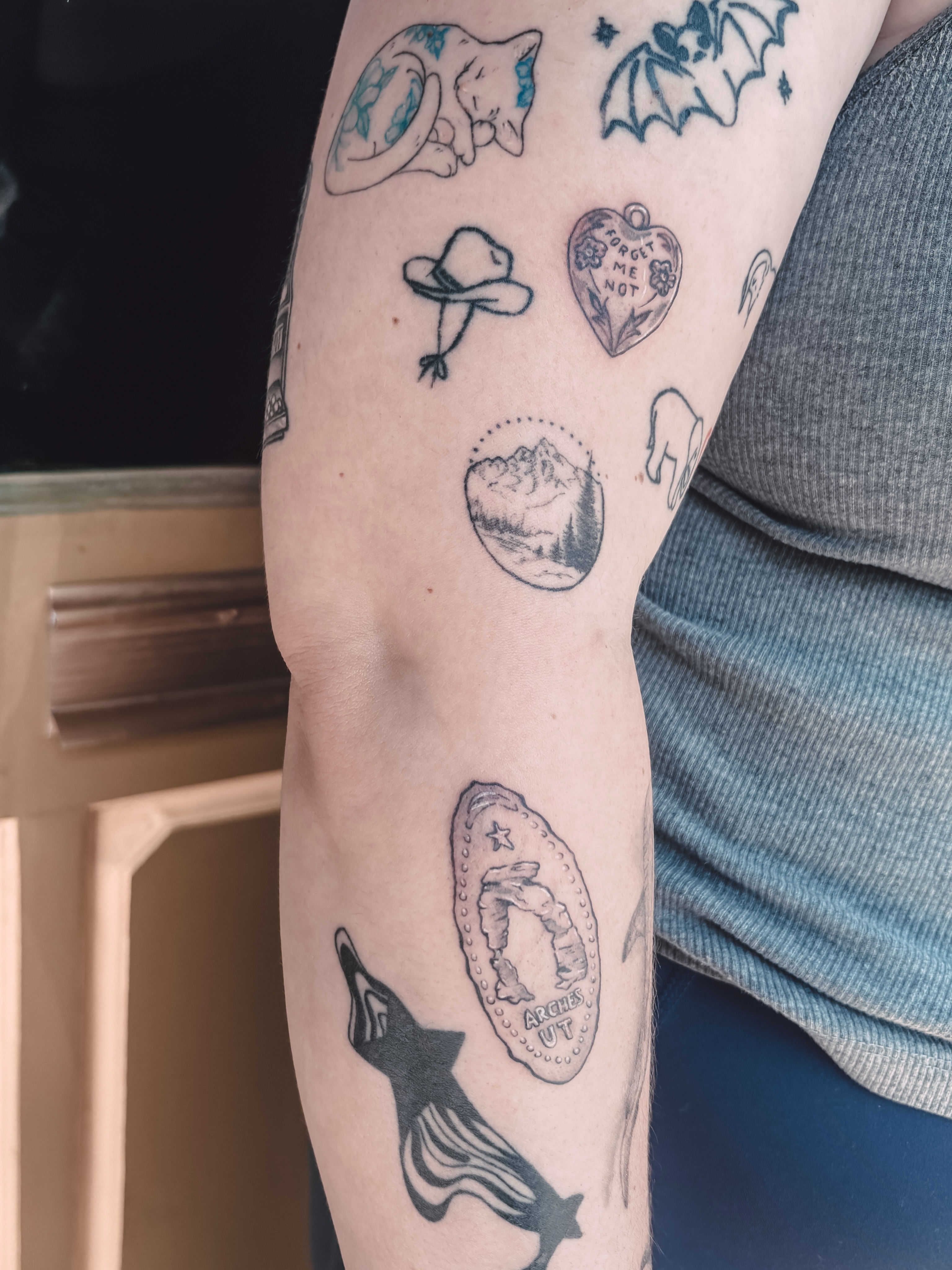 Multiple motifs black and grey tattoo on the forearm by Liz Cook