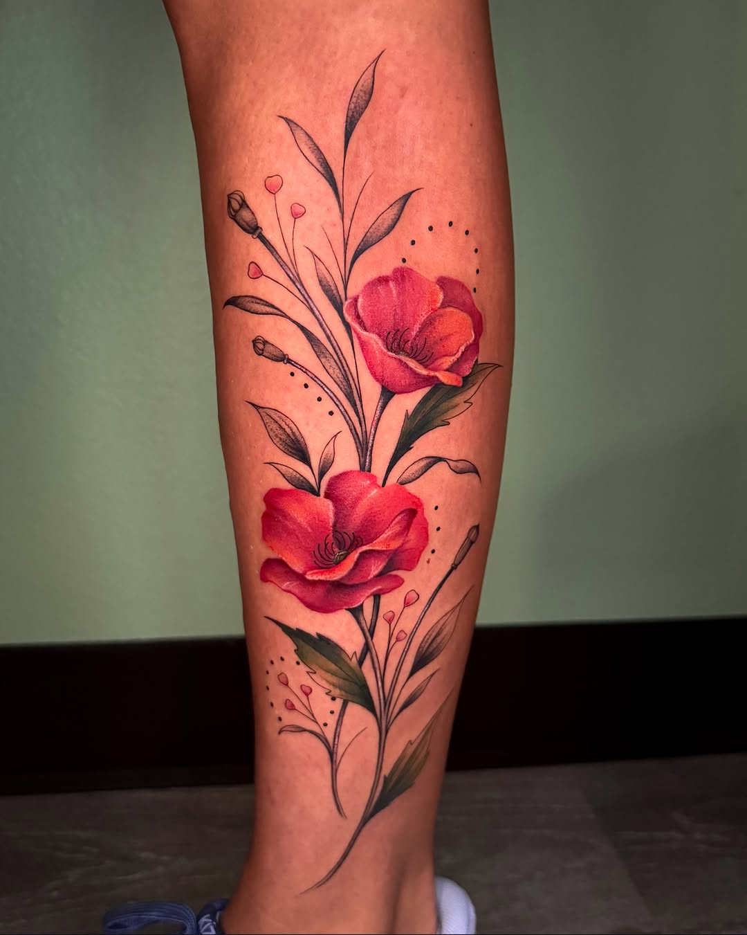Red poppies dotwork tattoo on the calf by Nichole Lorence
