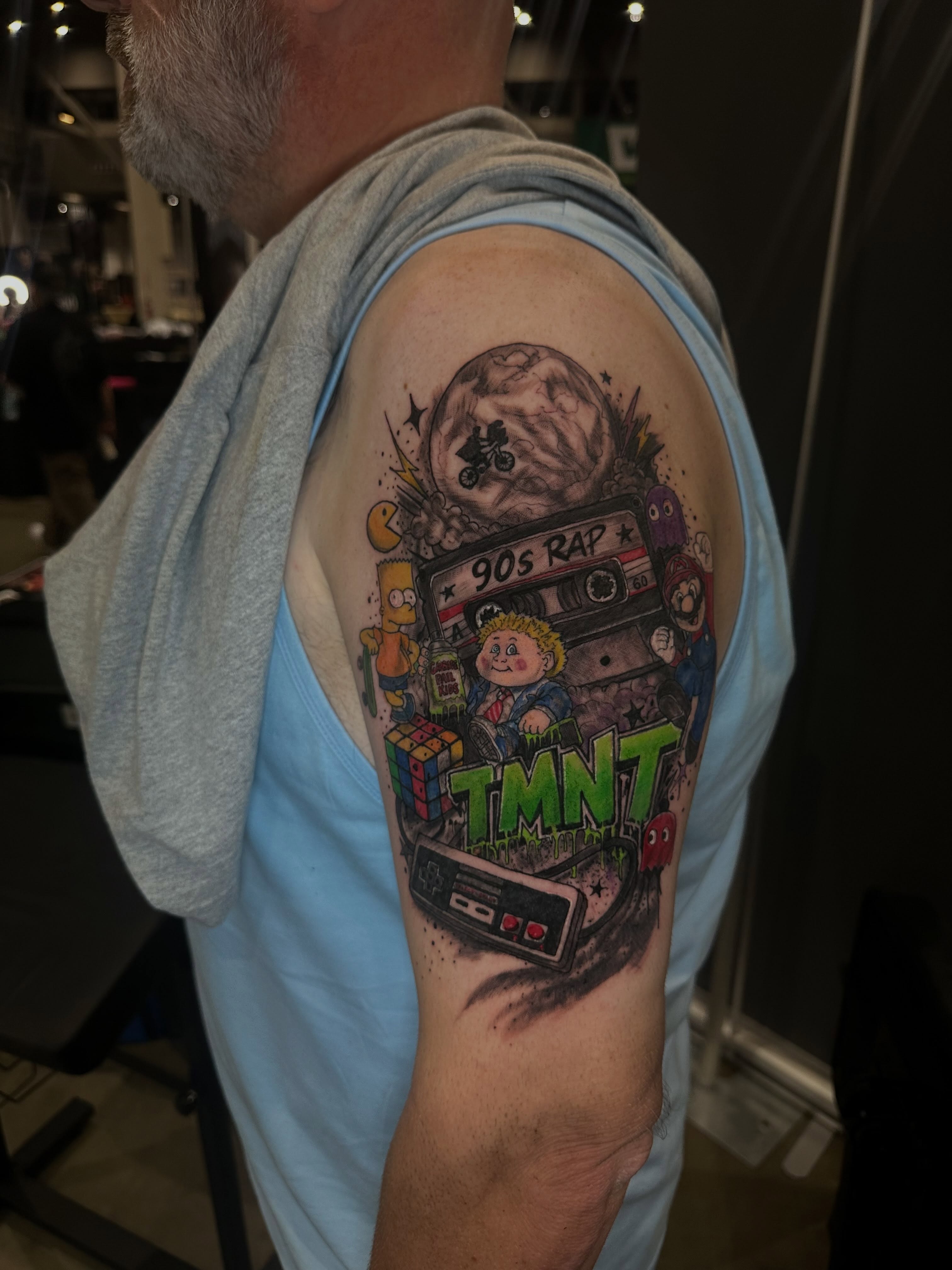 90s nostalgia new school tattoo on the upper arm by Aj Negrete Jr.