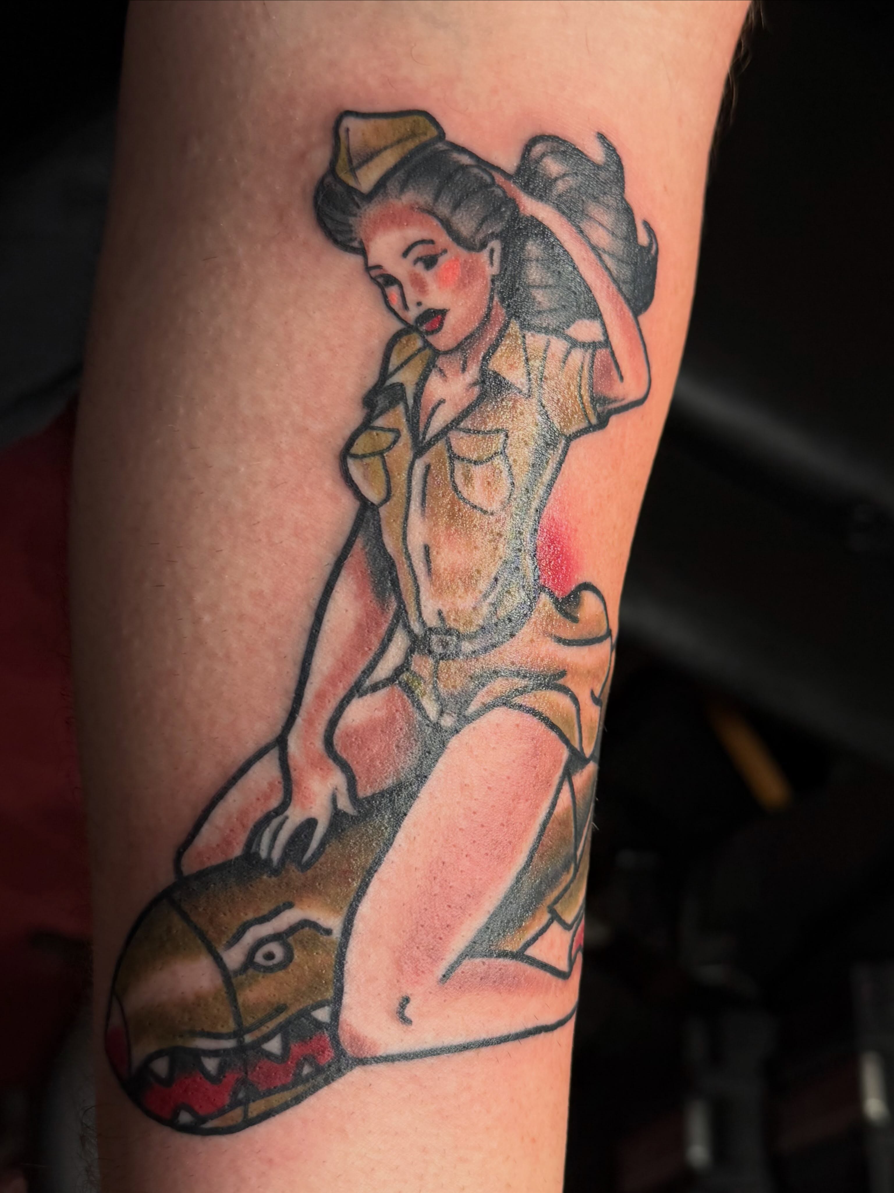 Pin-up girl riding a dragon American traditional tattoo on the forearm by Chris Smiseck