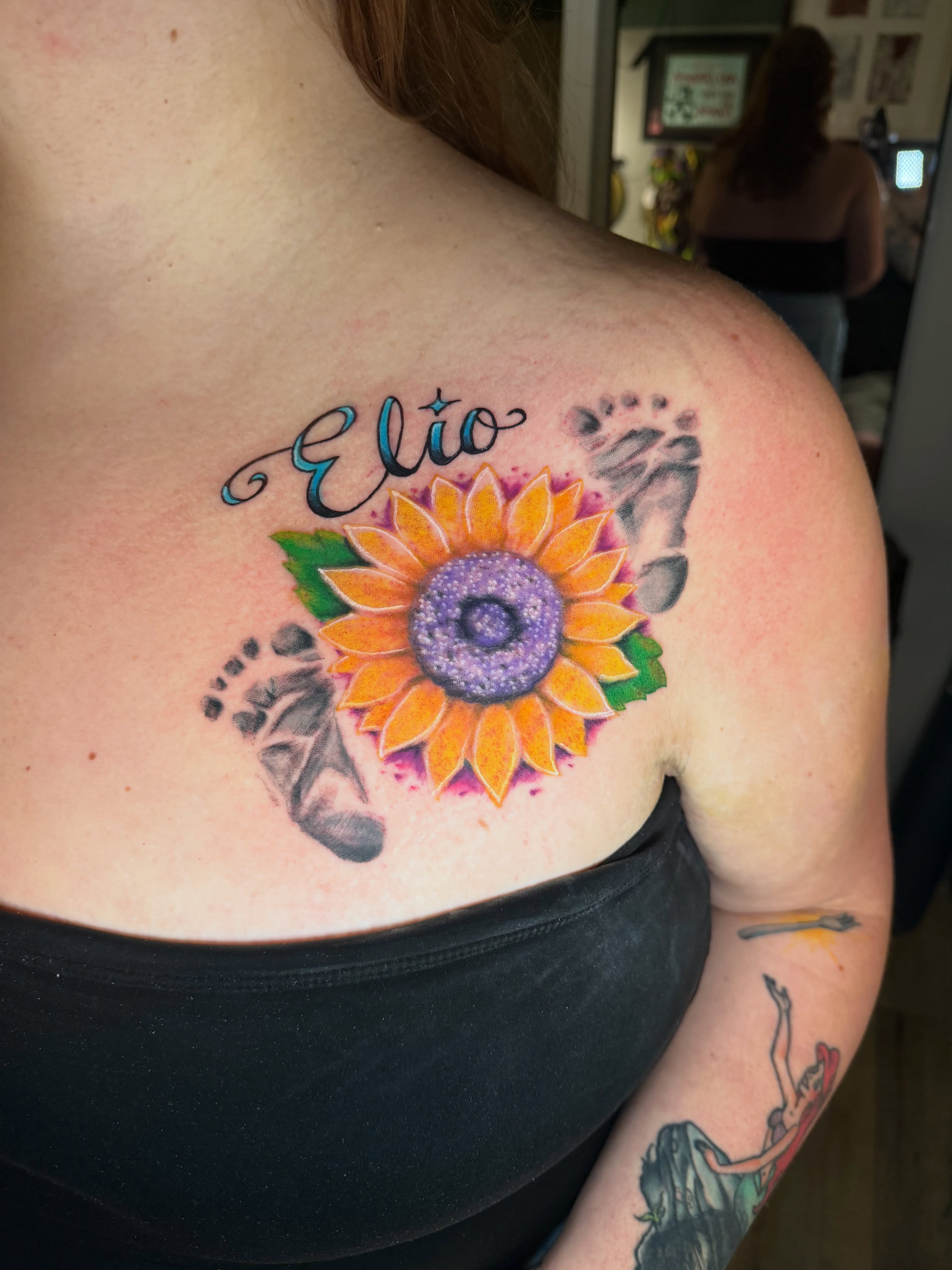 Sunflower and footprints dotwork tattoo on the shoulder by Loki Shane DeFriece