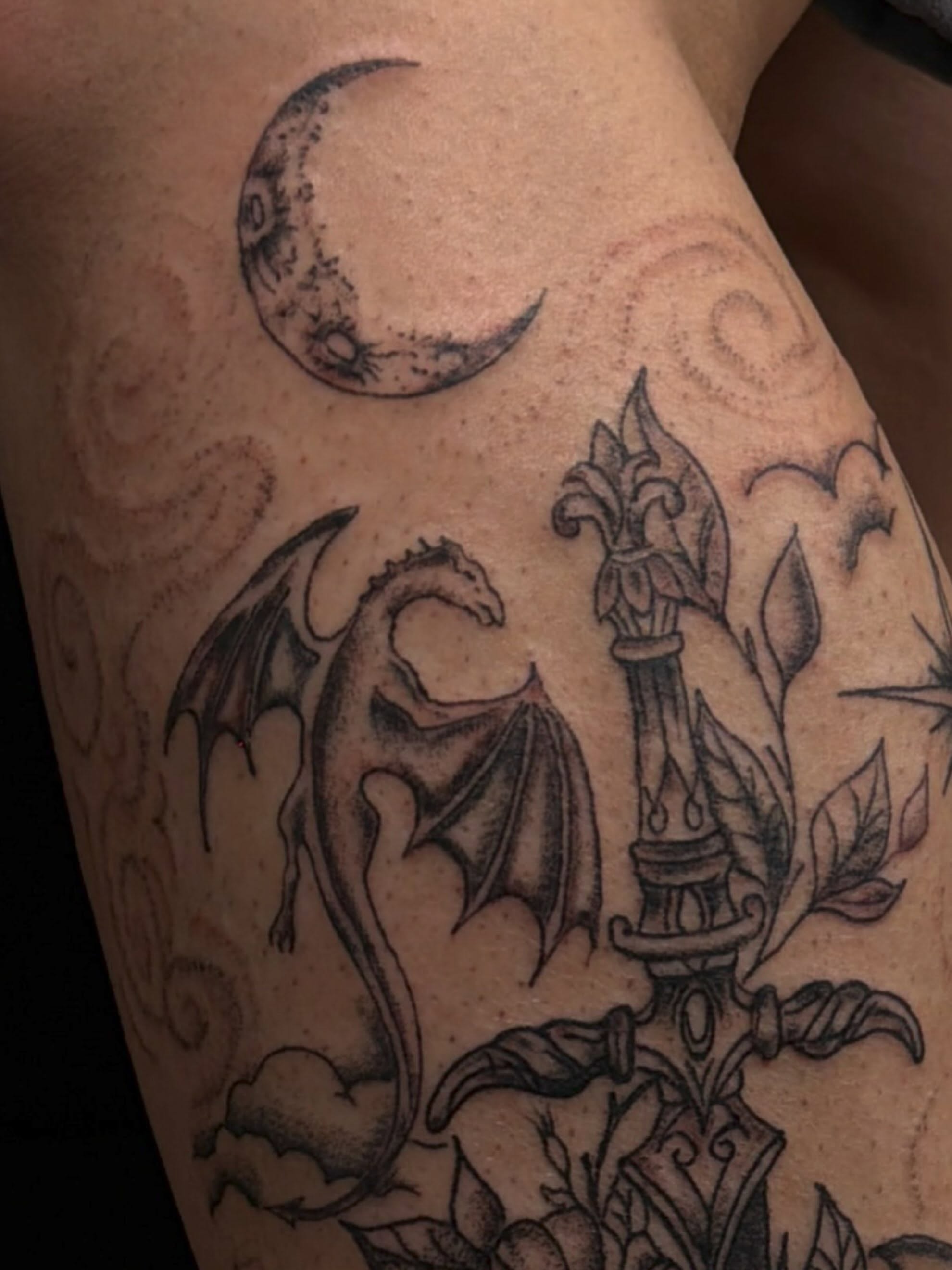 Dragon and crescent moon tribal tattoo on the thigh by cortez