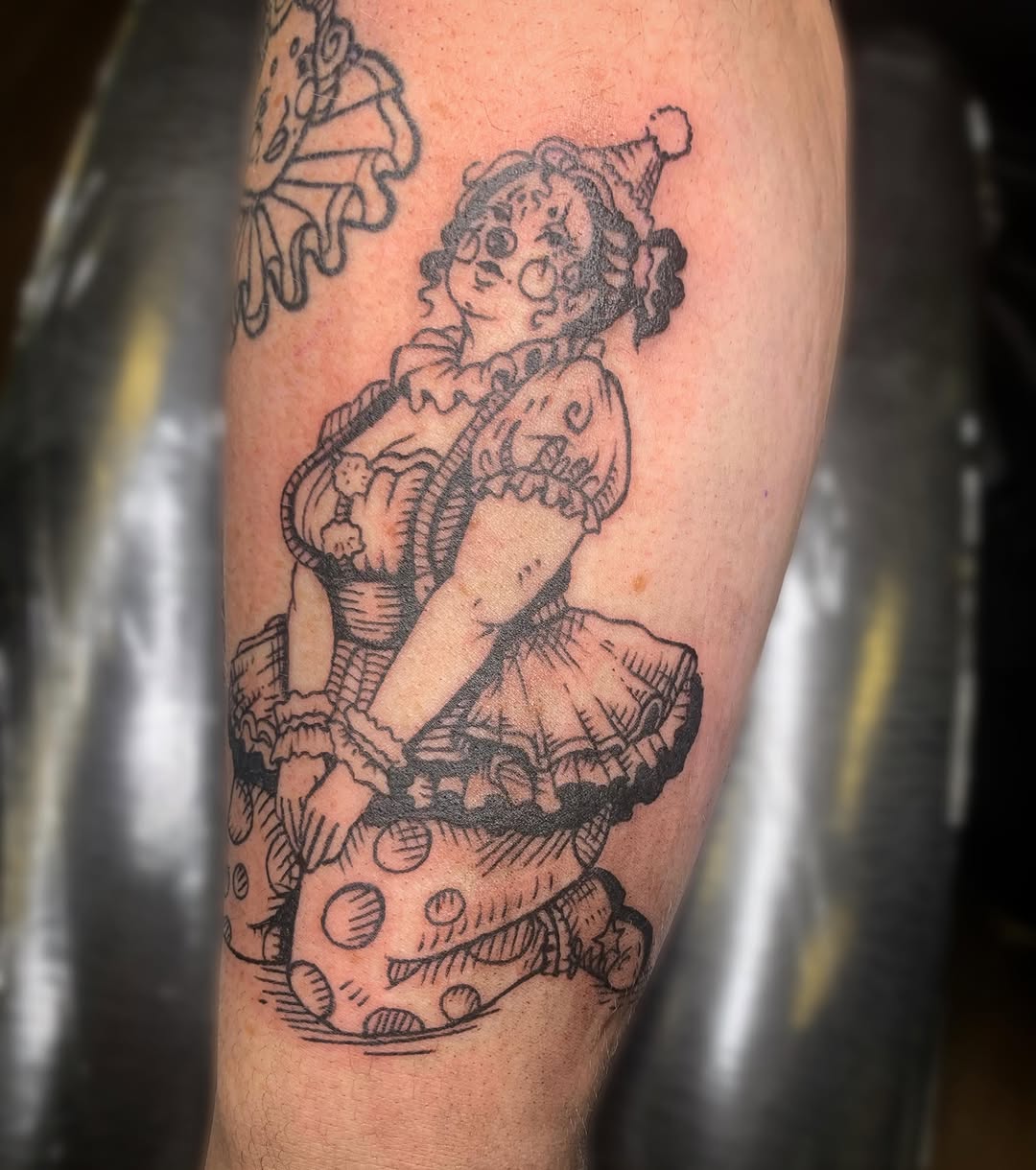 Rag doll American traditional tattoo on the forearm by Ava Glory Tattoos