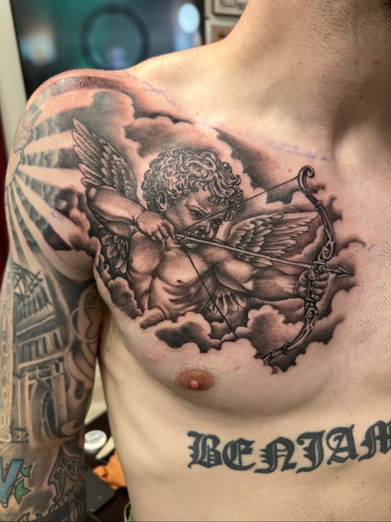 Cherub with bow realism tattoo on the chest by Isaac Ortiz-Riendeau