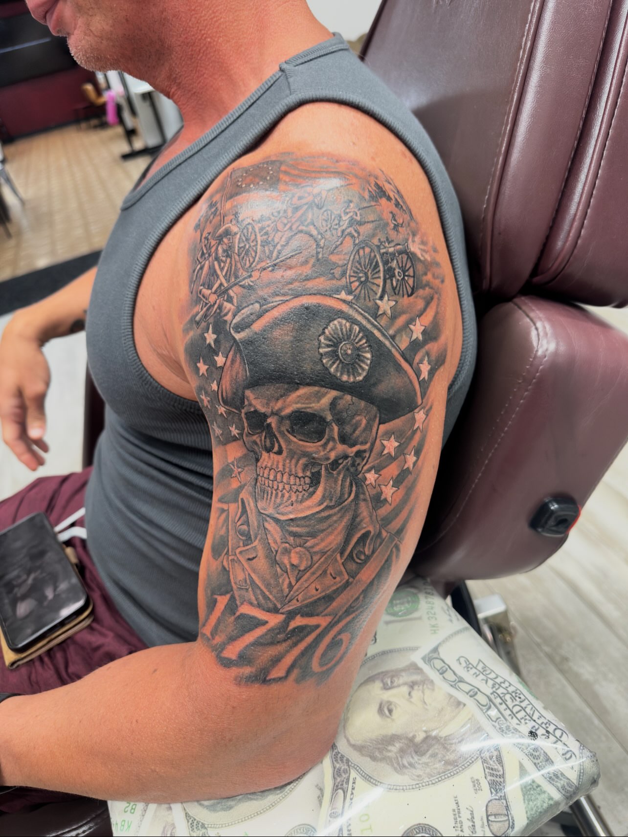 Skull wearing hat American traditional tattoo on the upper arm by Isaac Ortiz-Riendeau