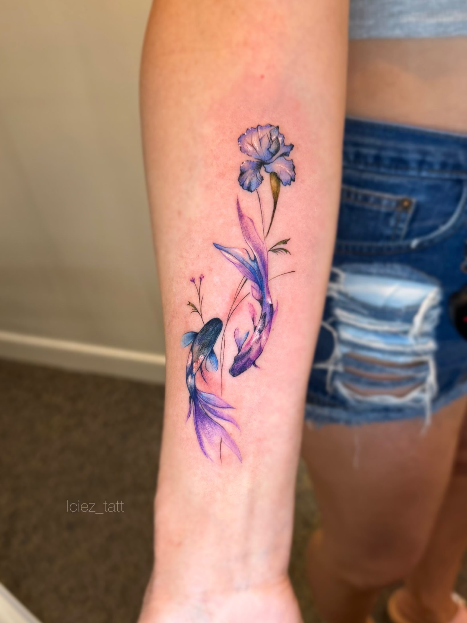 Koi fish and flower watercolor tattoo on the forearm by Iciez