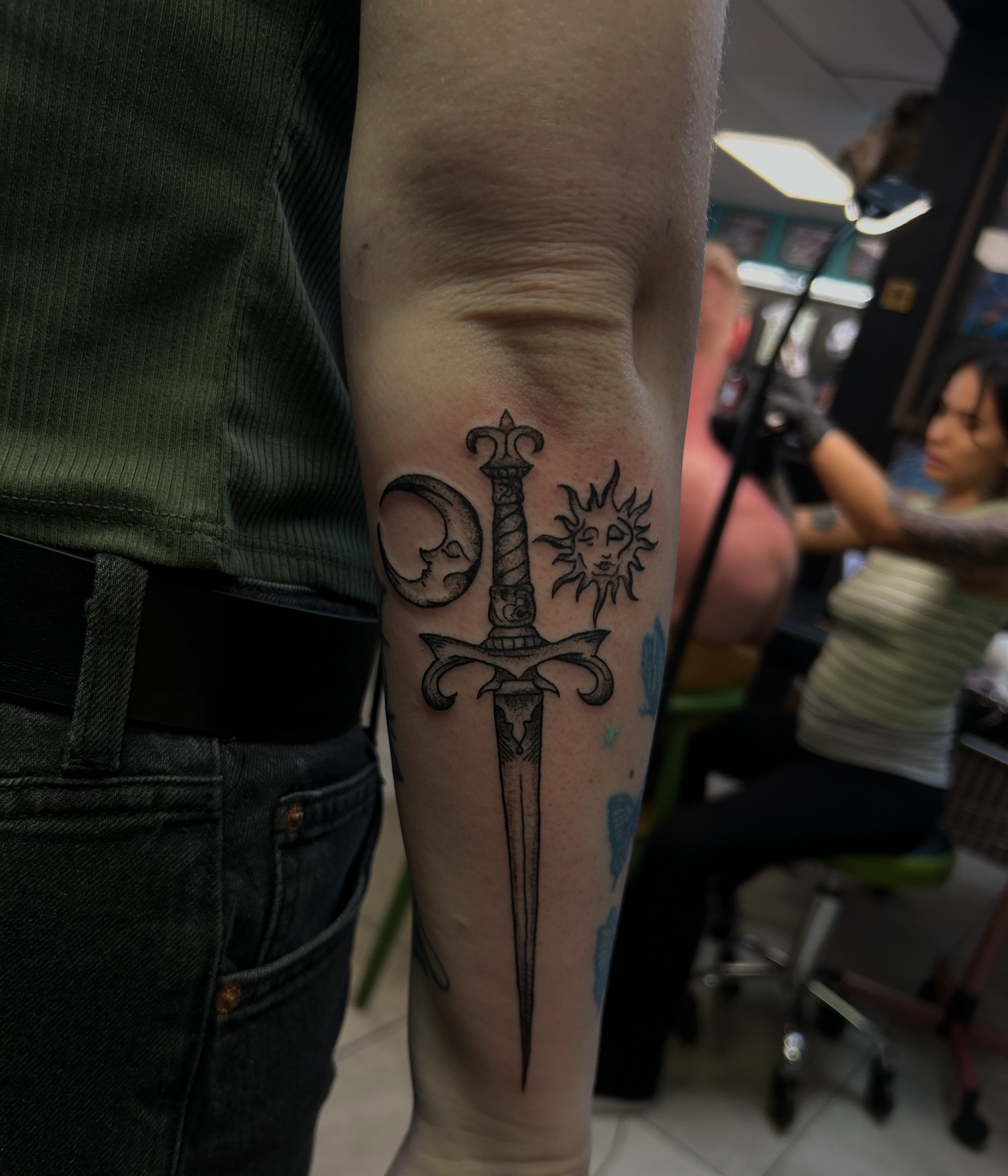 Sword and sun black and grey tattoo on the forearm by Torrey, Austin, Texas
