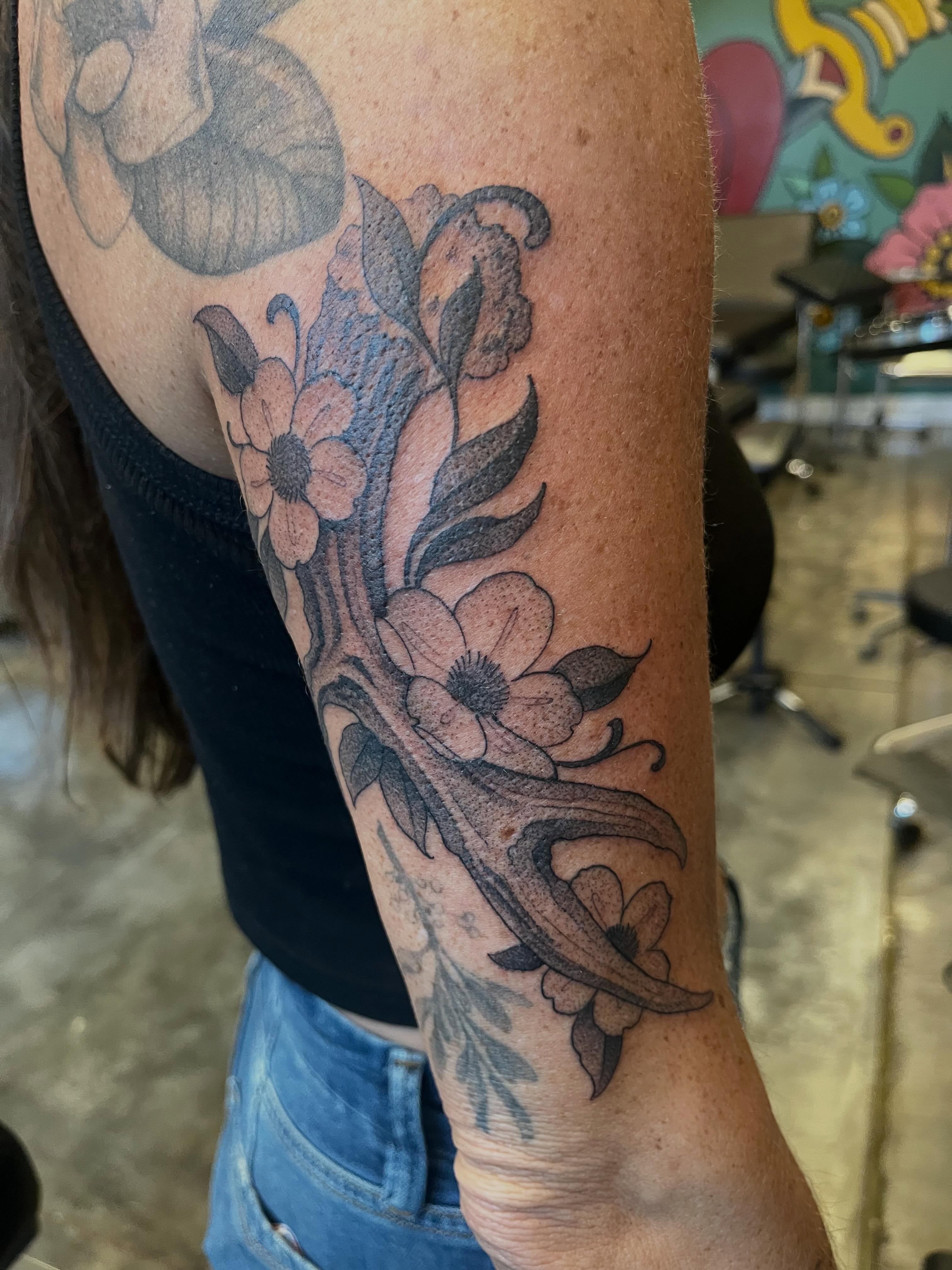 Floral arrangement black and grey tattoo on the forearm by Ian White