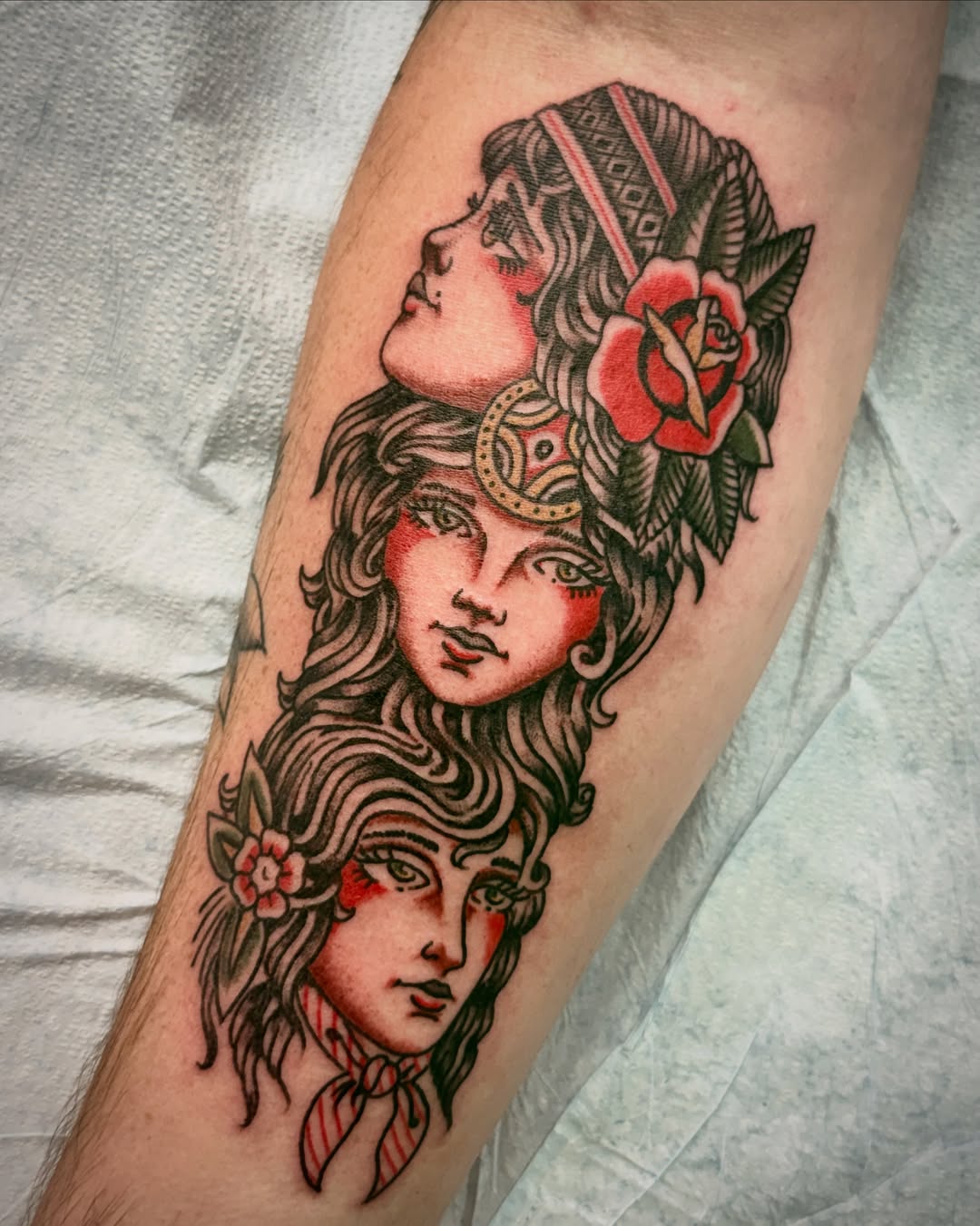 Woman's faces American traditional tattoo on the forearm by Austin Liebst, Wichita, Kansas