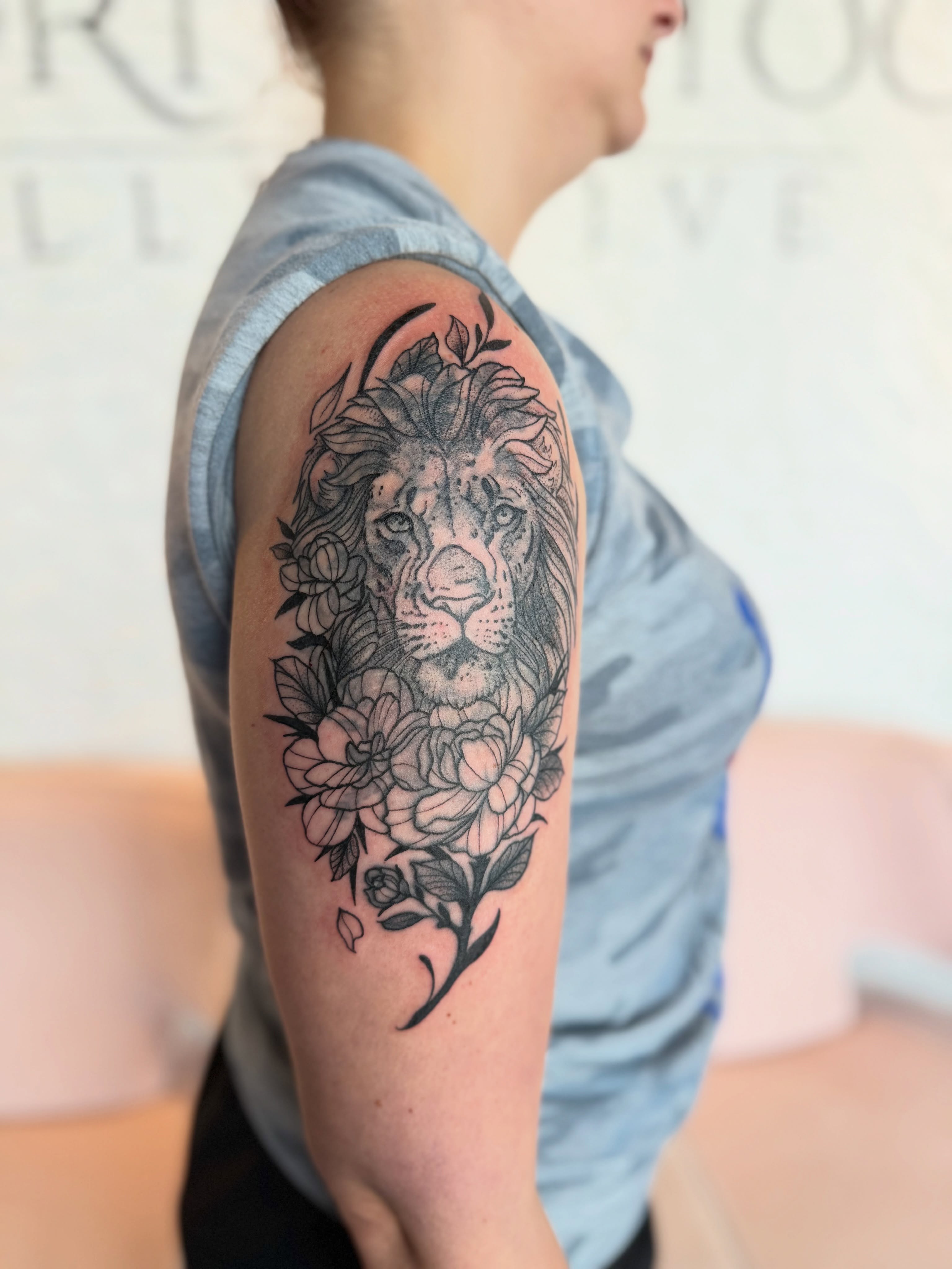 Lion and flowers realism tattoo on the forearm by Kyndall Lynn, Waxahachie, Texas