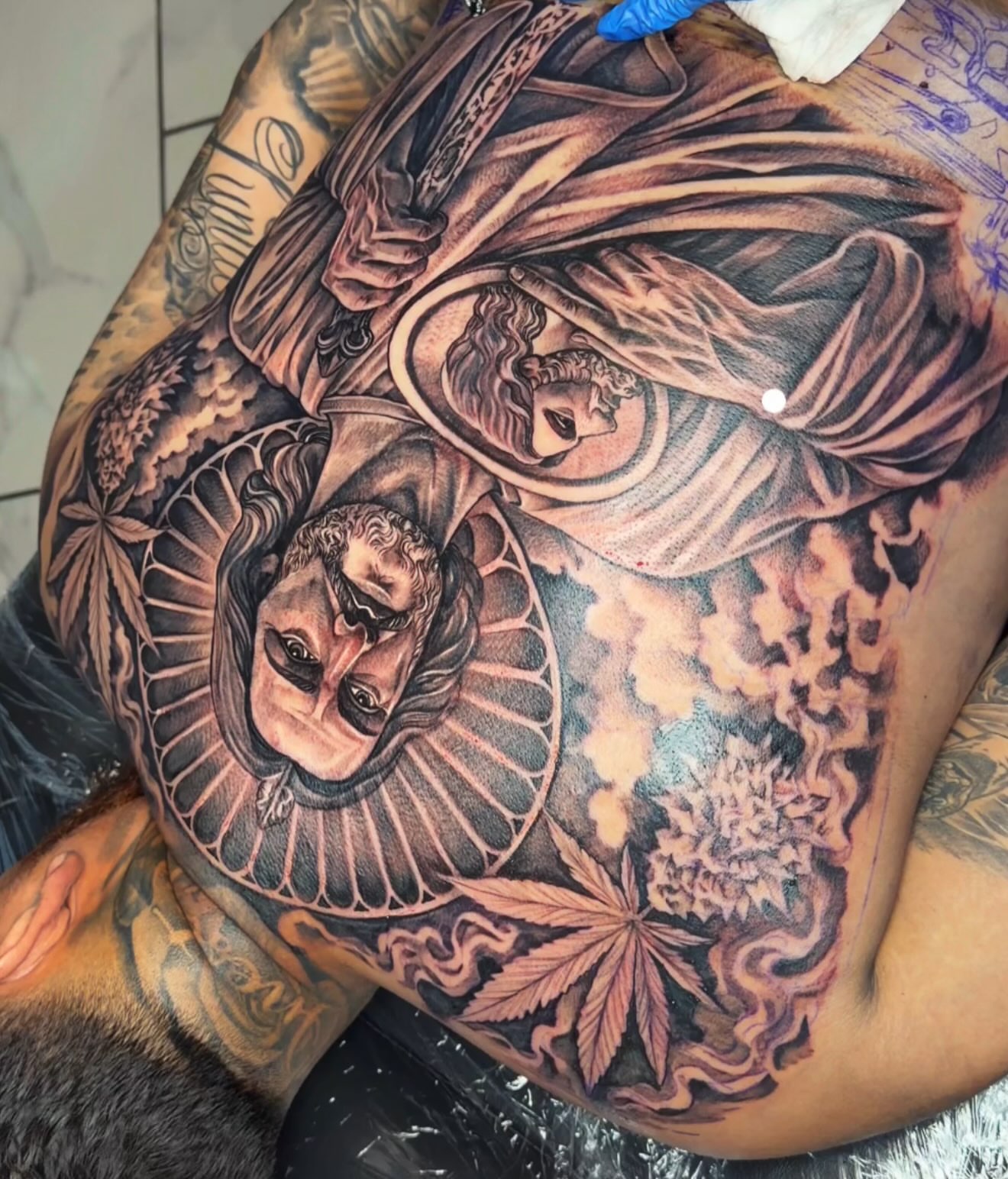 Religious figure with mask realism tattoo on the thigh by Adrian gonzalez...
