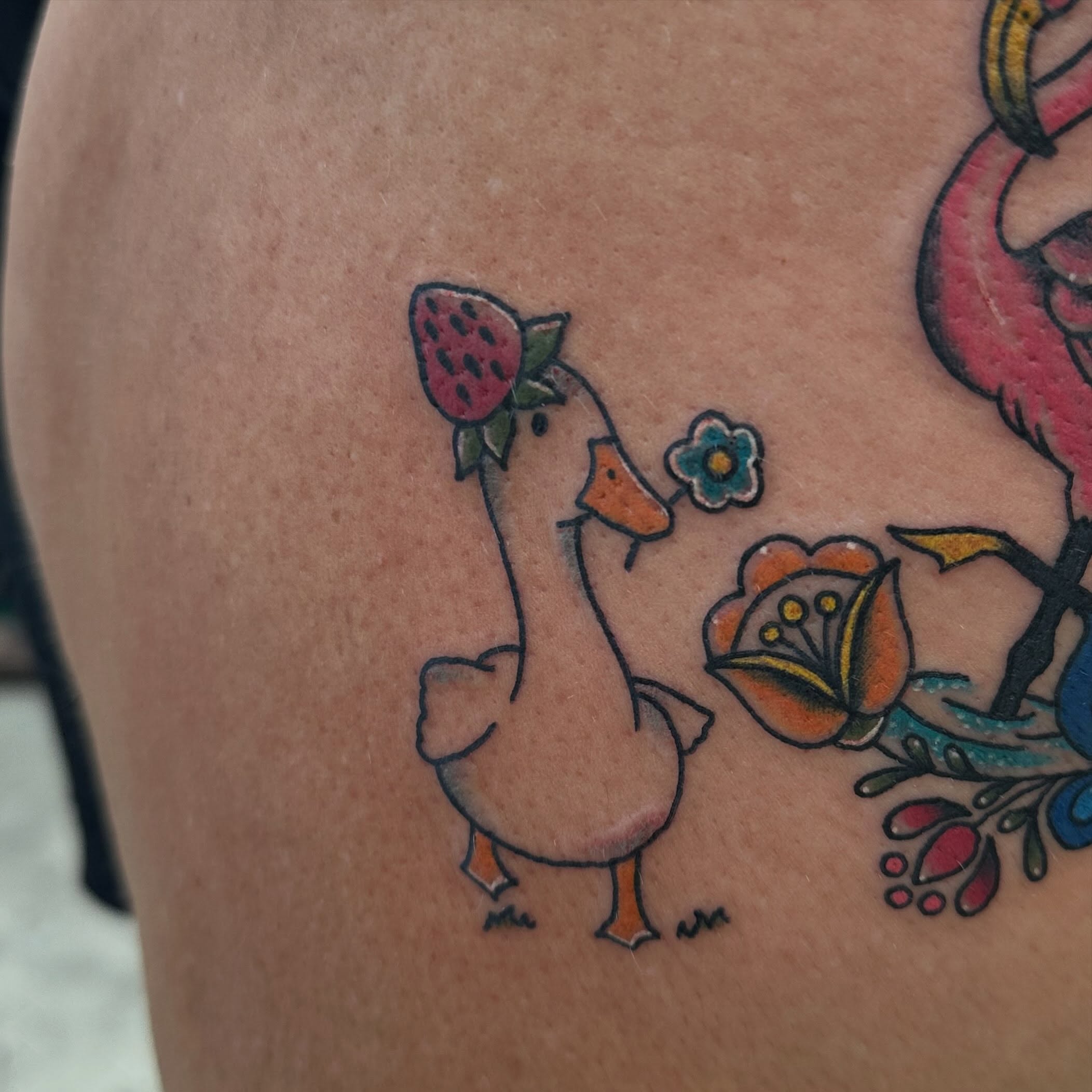 Goose with strawberry new school tattoo on the thigh by Nicki Hoverson