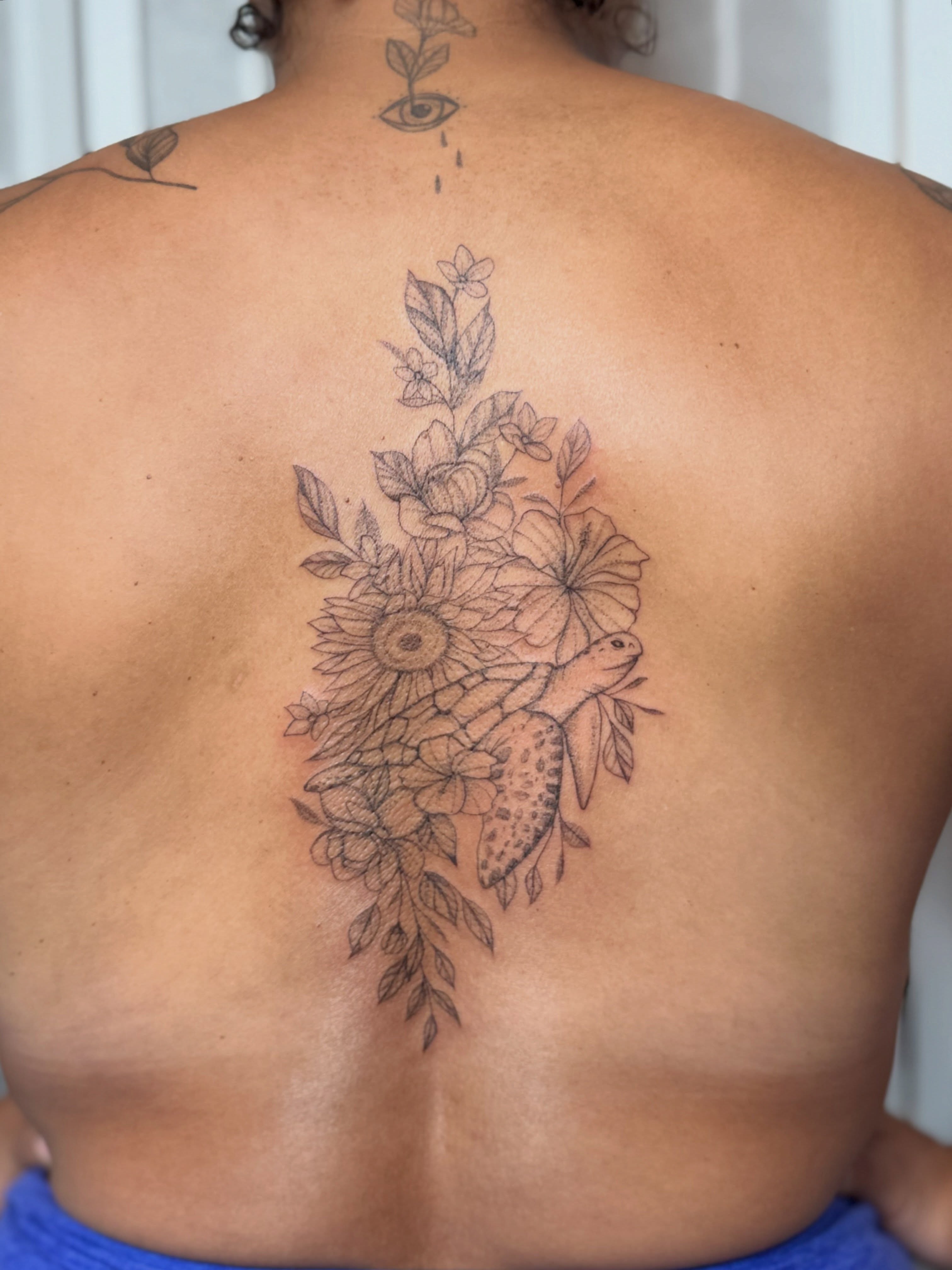 Floral arrangement with turtle black and grey tattoo on the back by Dama