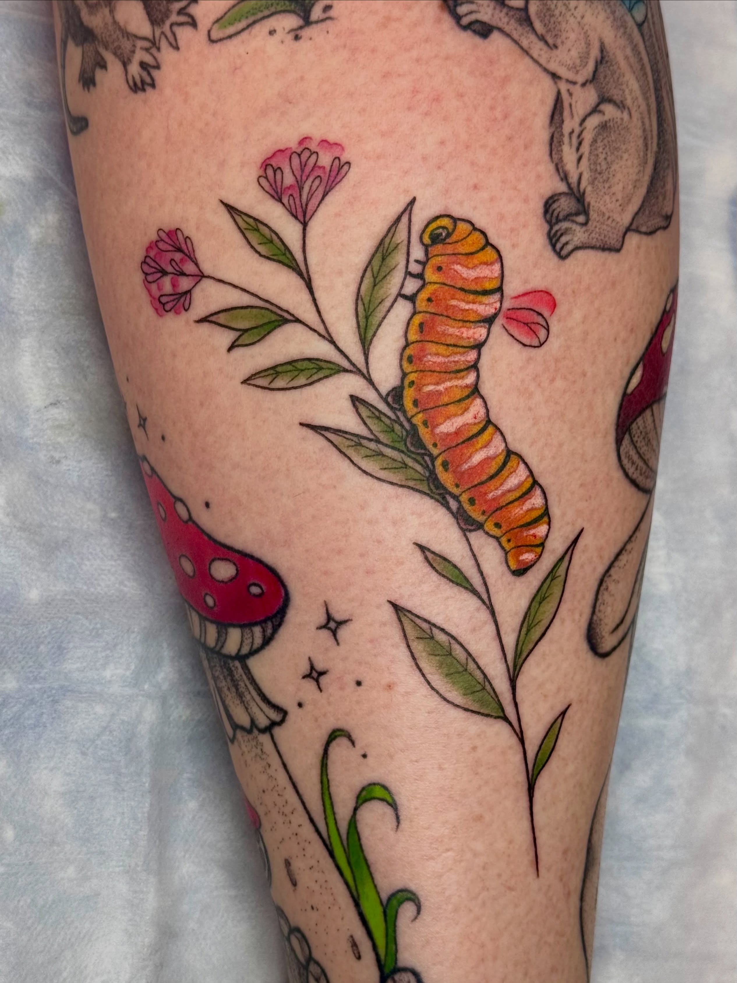 Caterpillar and flowers new school tattoo on the forearm by Caitlynn Austin