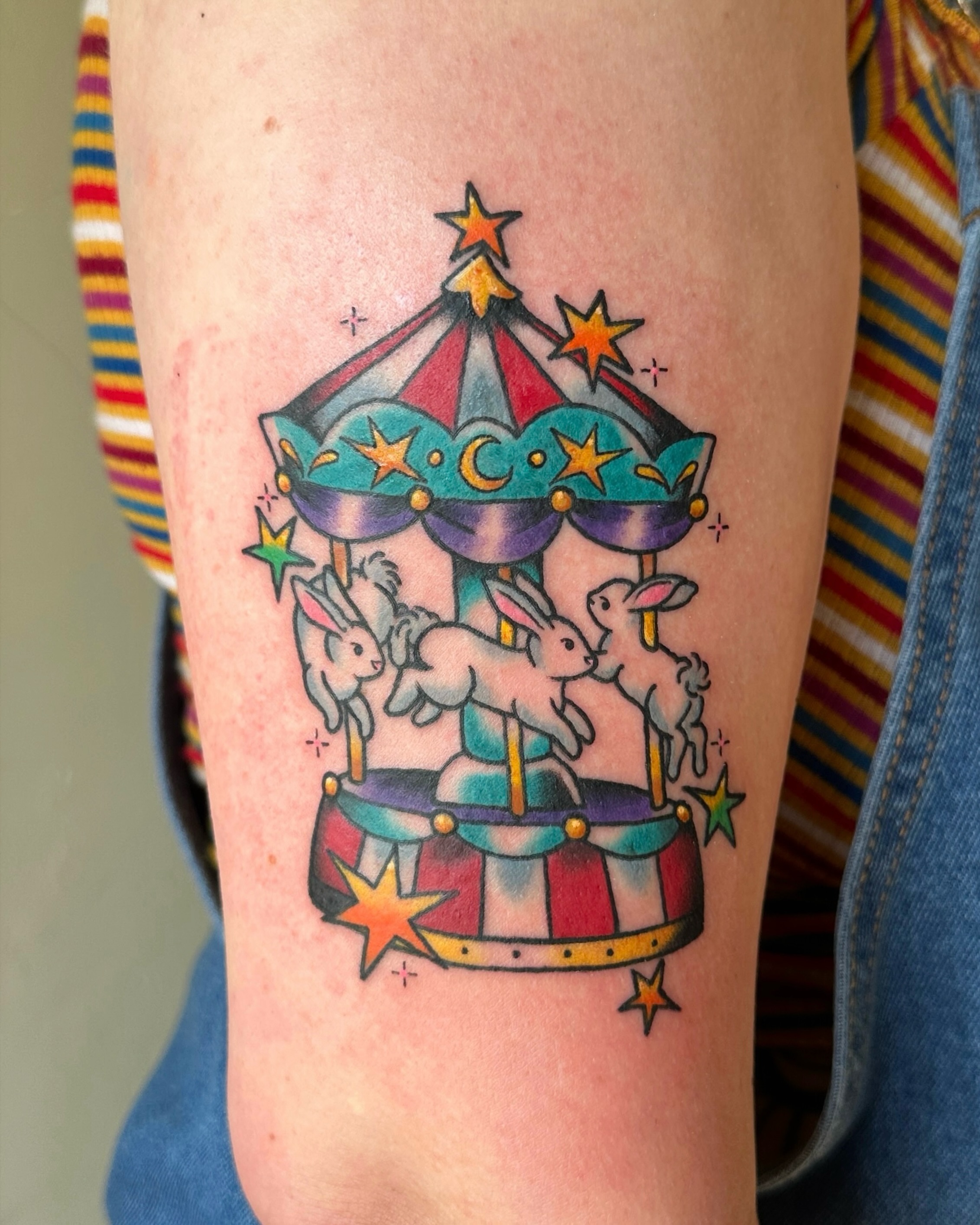 Carousel with rabbits new school tattoo on the forearm by Paige Ochoa