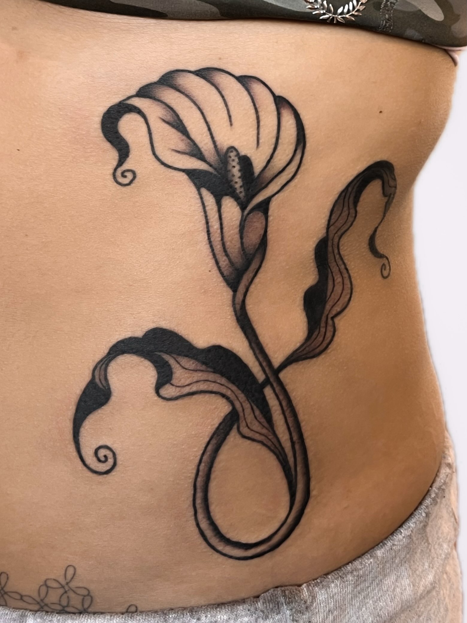 Calla lily black and grey tattoo on the torso by nina