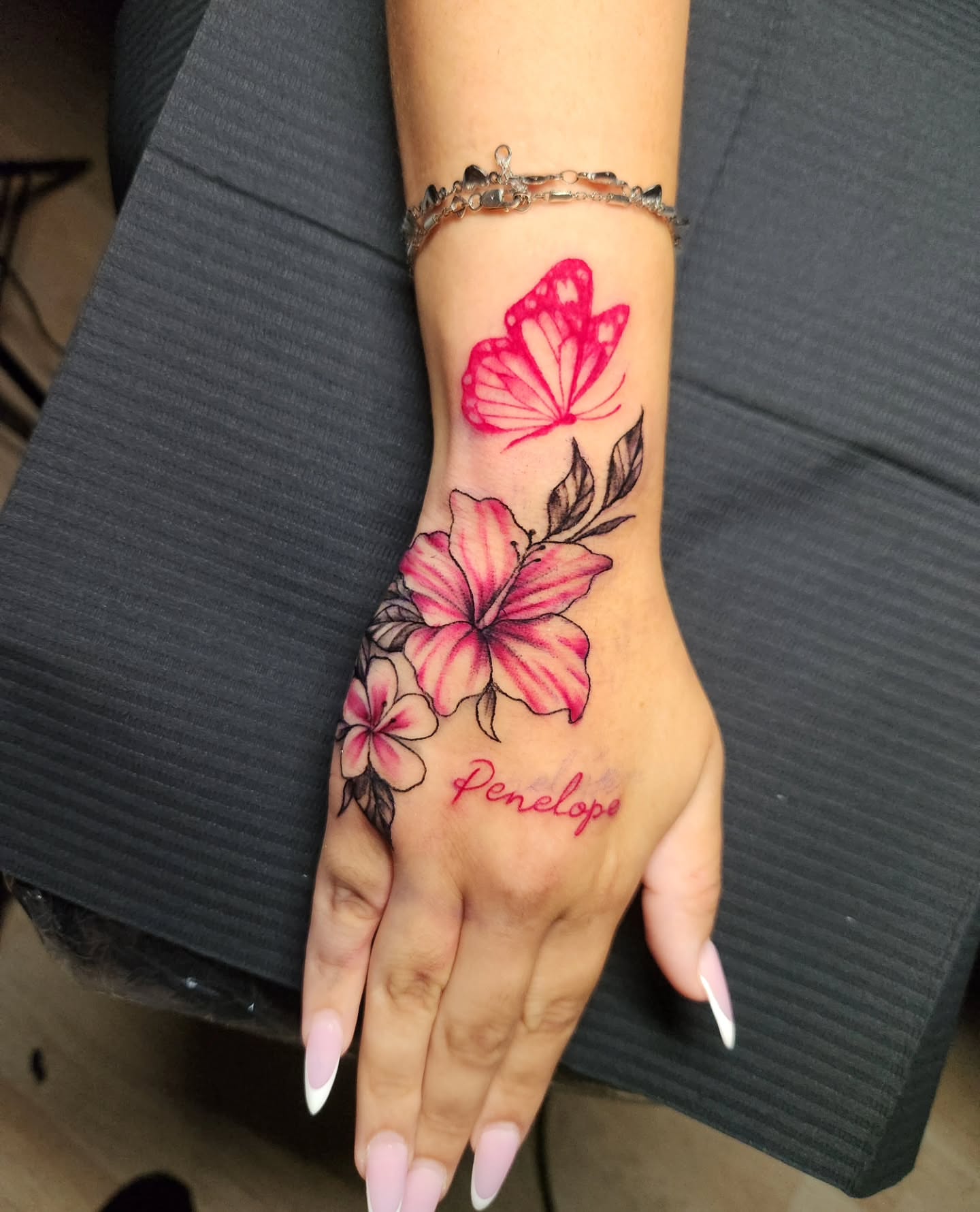 Hibiscus flowers and butterfly new school tattoo on the hand by Abby Renteria