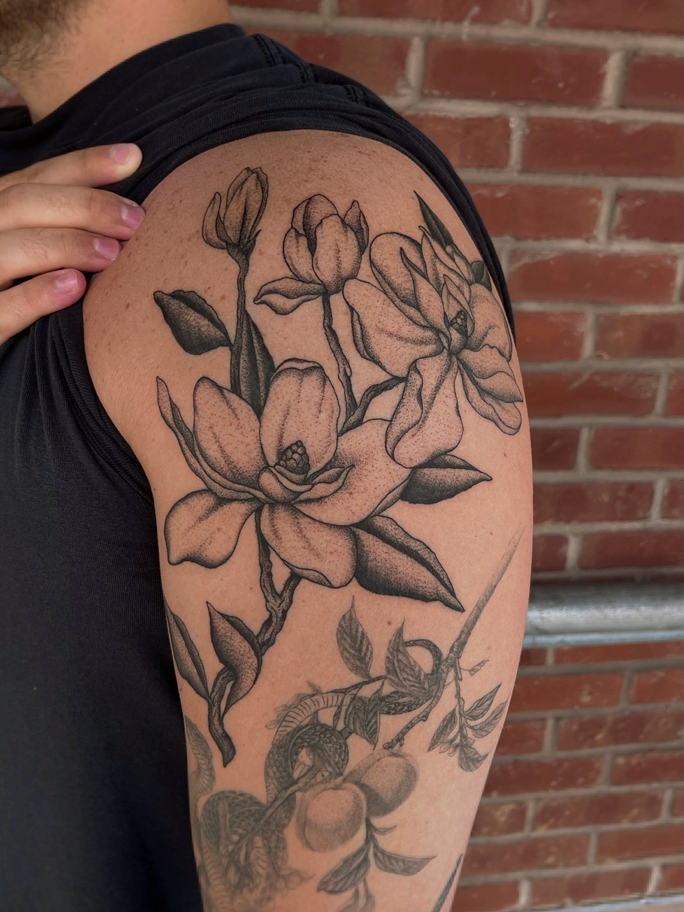 Magnolia flowers black and grey tattoo on the shoulder by Jackson Kirchhoff