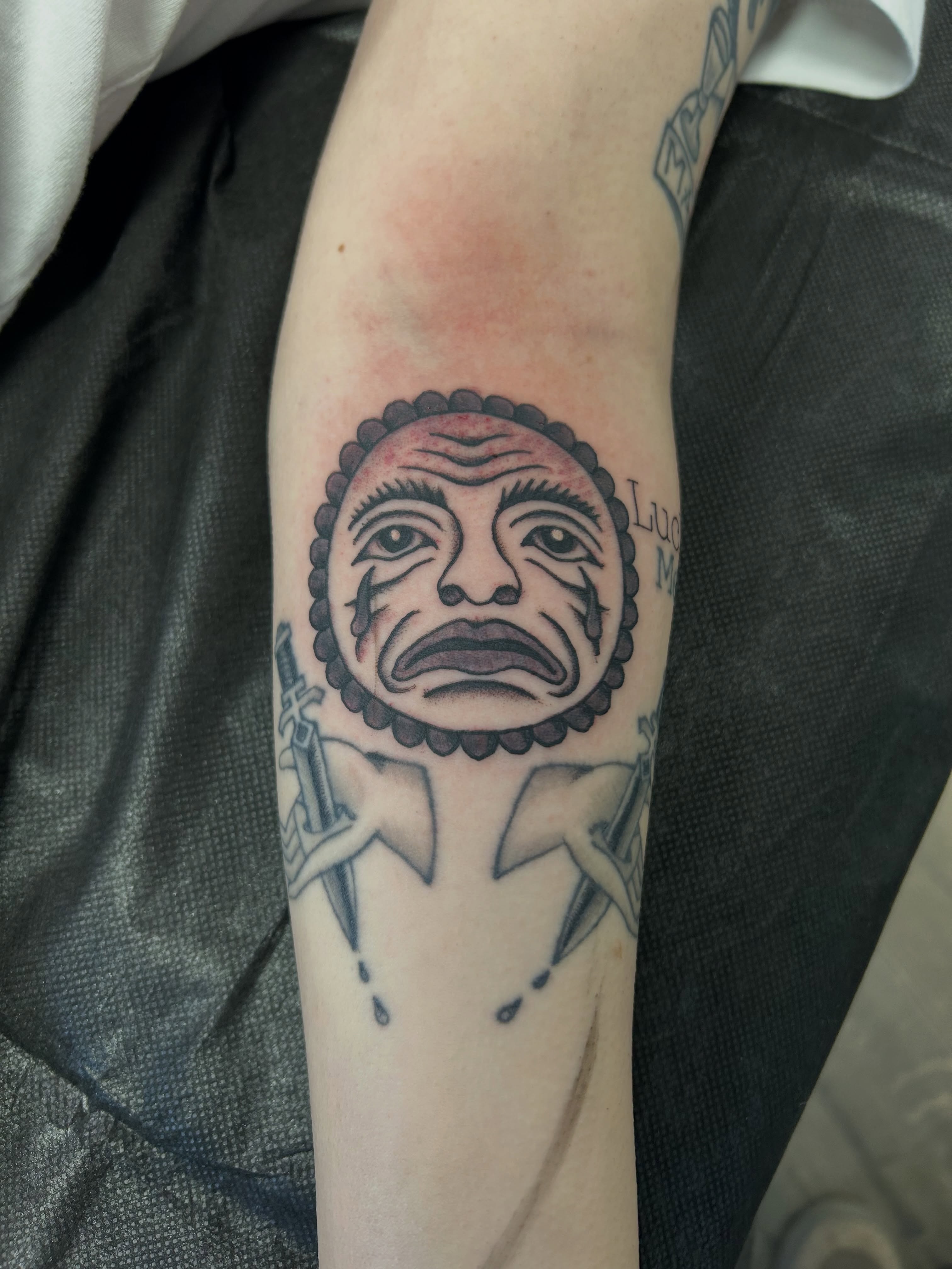 Crying face black and grey tattoo on the forearm by Mike "Yogi" Trube