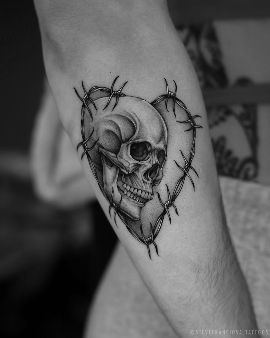 Skull in barbed wire heart realism tattoo on the forearm by Steve Franciosa
