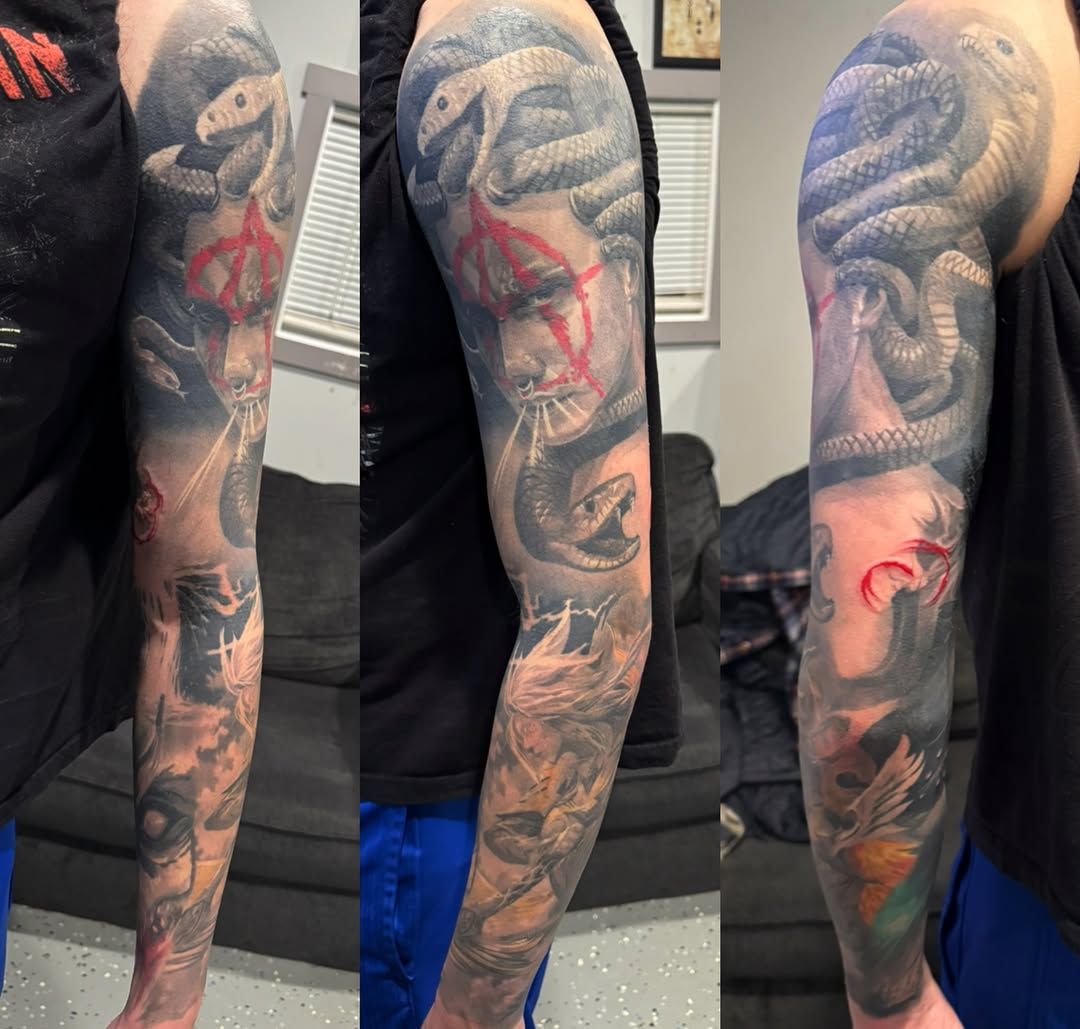 Snake and face realism tattoo on the upper arm by marcus labonne