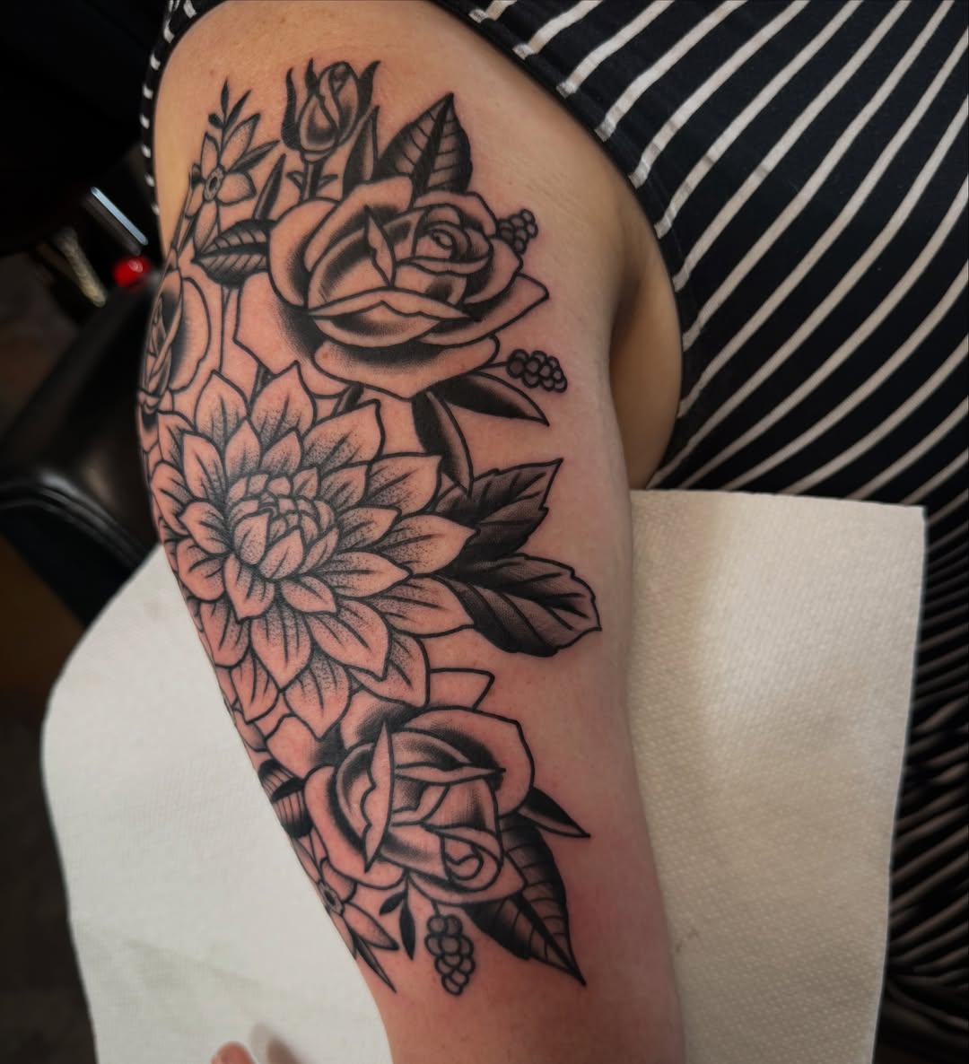 Floral arrangement black and grey tattoo on the upper arm by Christopher Mikesell