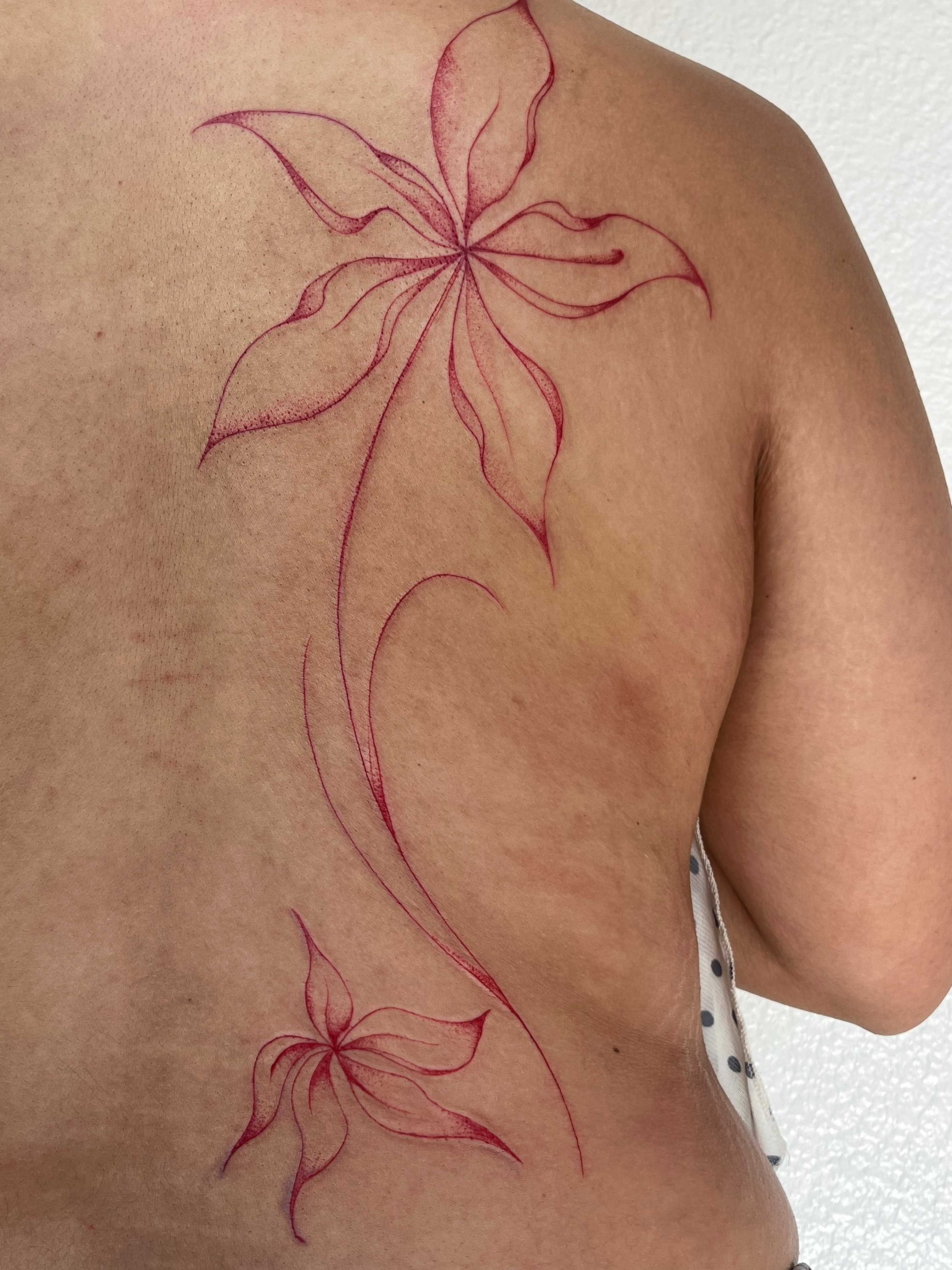 Lily fine line tattoo on the back by Sara Atamian, San Diego, California