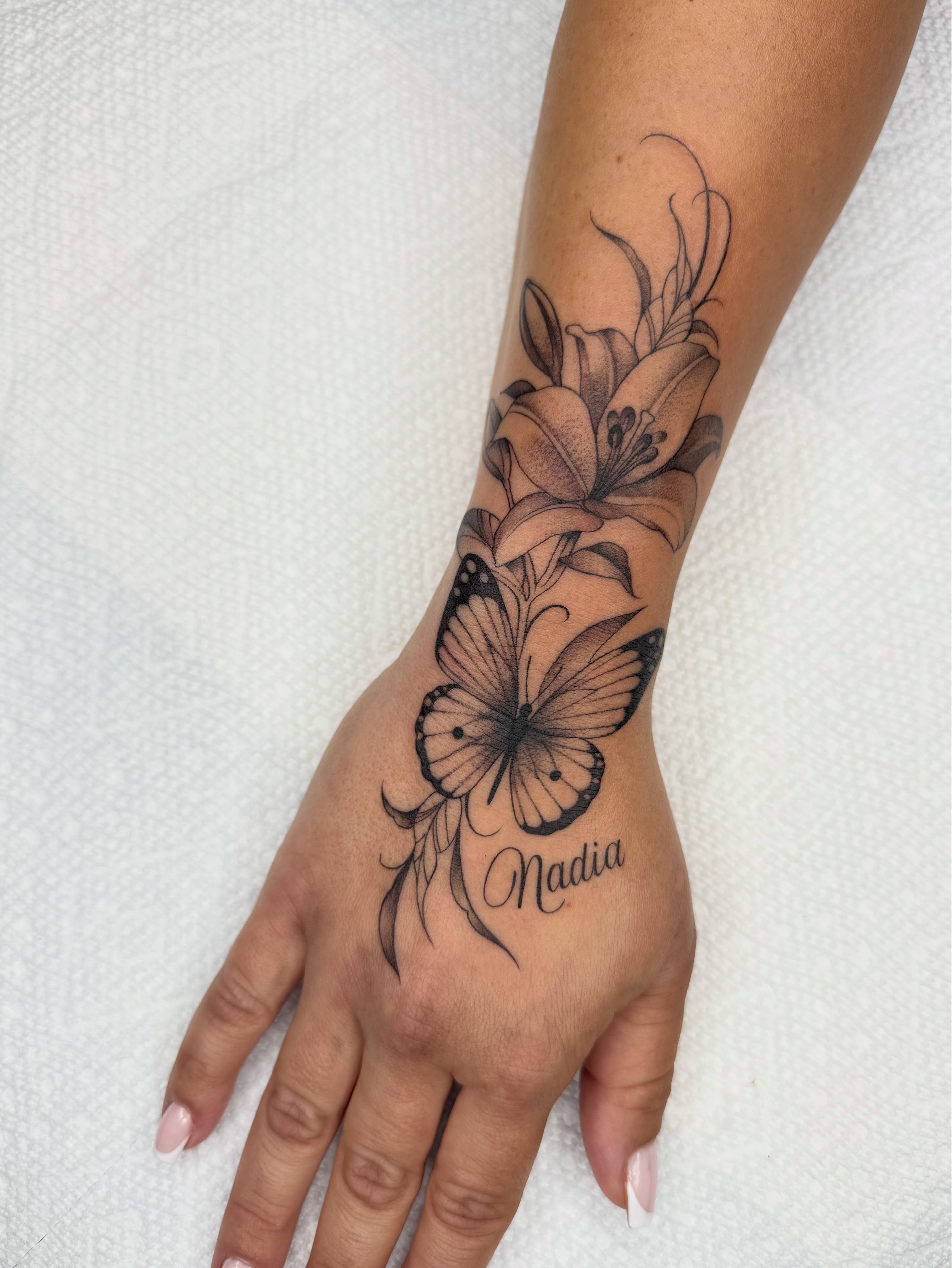 Butterfly and lily black and grey tattoo on the forearm by Tara Crespi - Female Tattoo Artist 💜