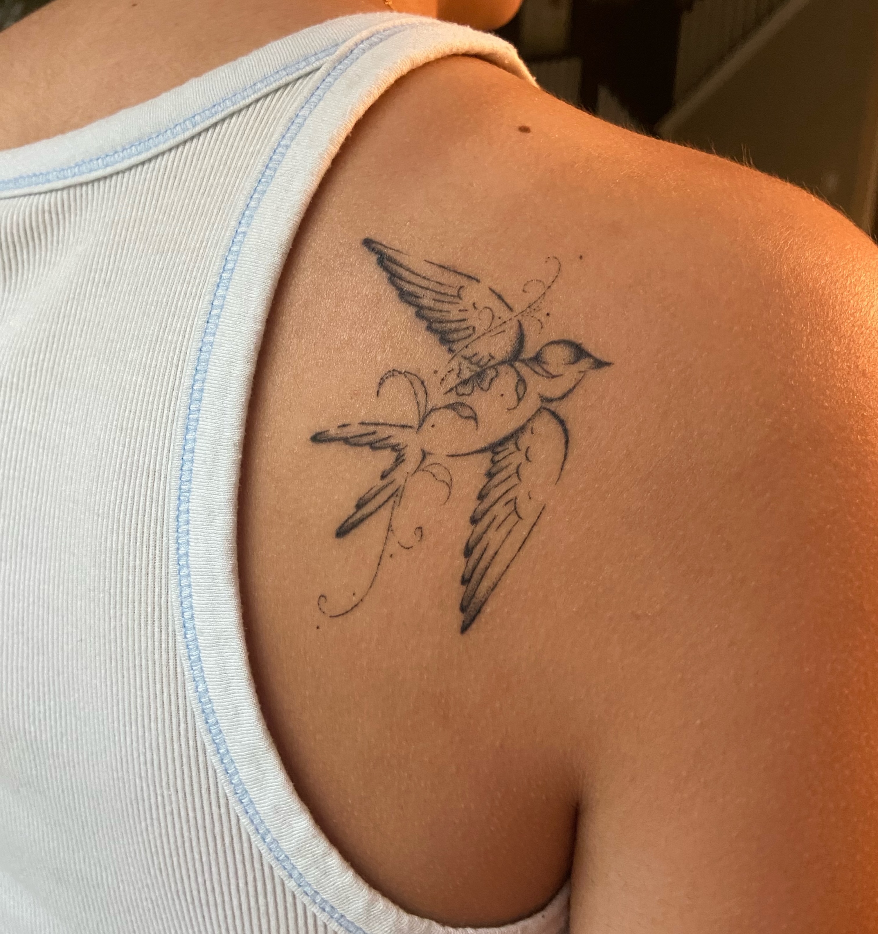 Swallow black and grey tattoo on the shoulder by Fine Line Tattoos