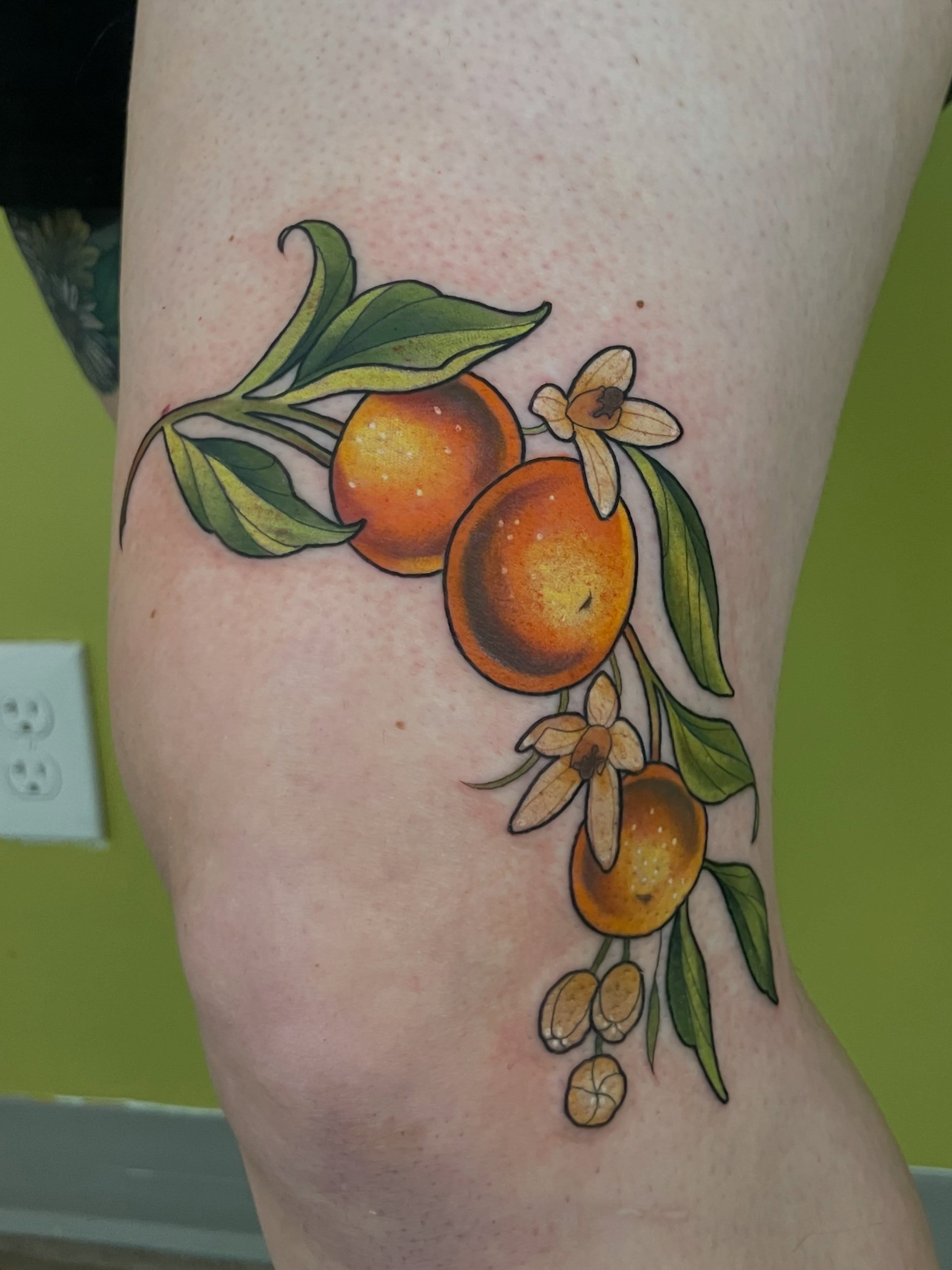 Orange fruit realism tattoo on the forearm by ✨Erin Haines✨