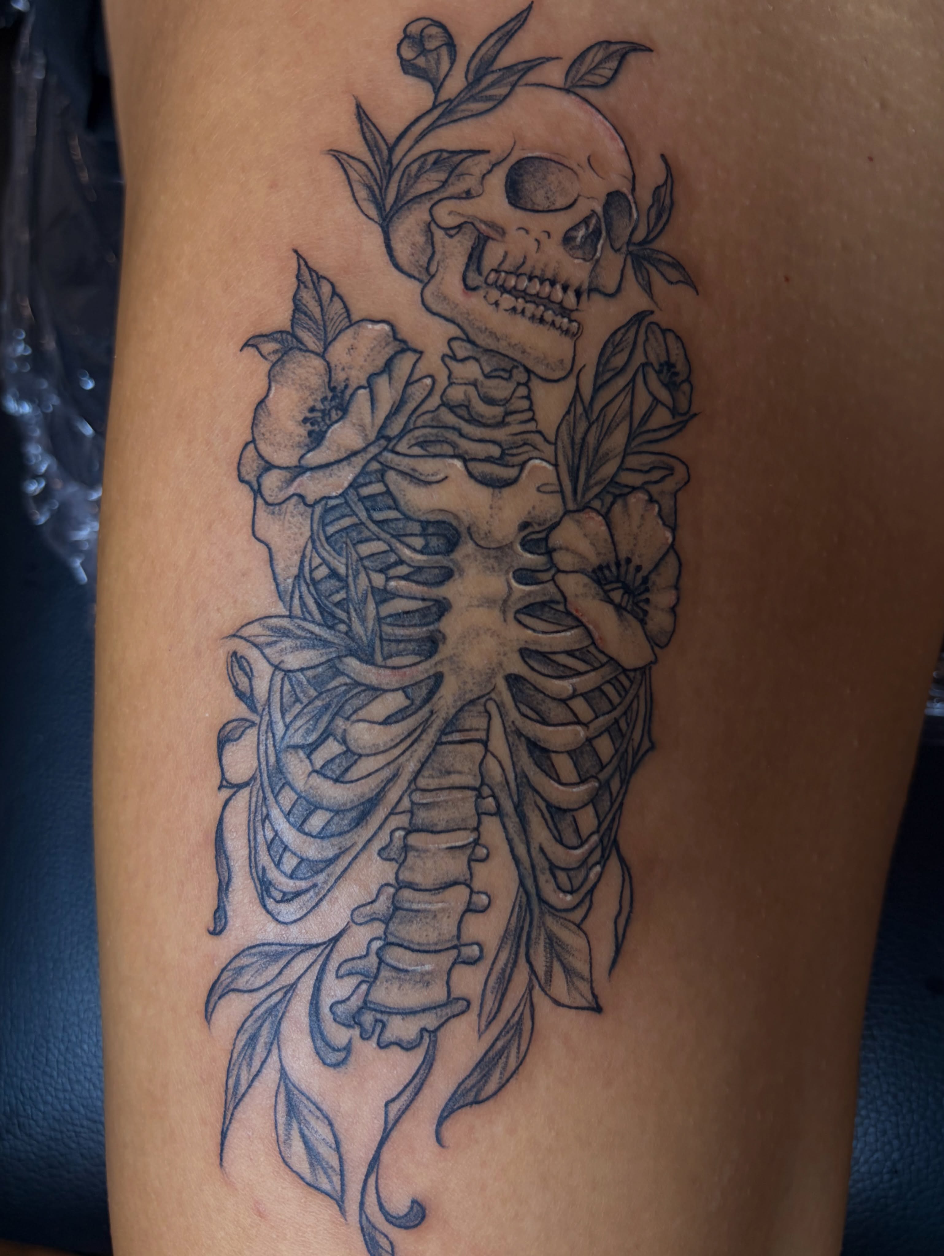 Skeleton with flowers realism tattoo on the thigh by Inked By E, Philadelphia, Pennsylvania