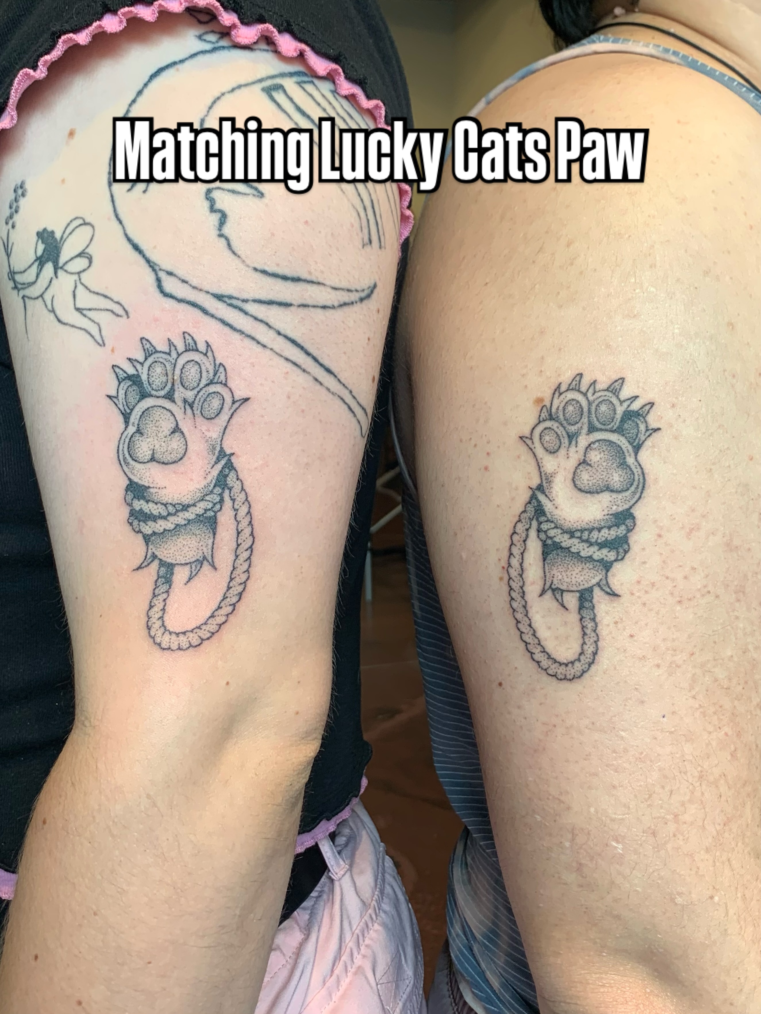 Lucky cat paw black and grey tattoo on the upper arm by Lex Lloyd