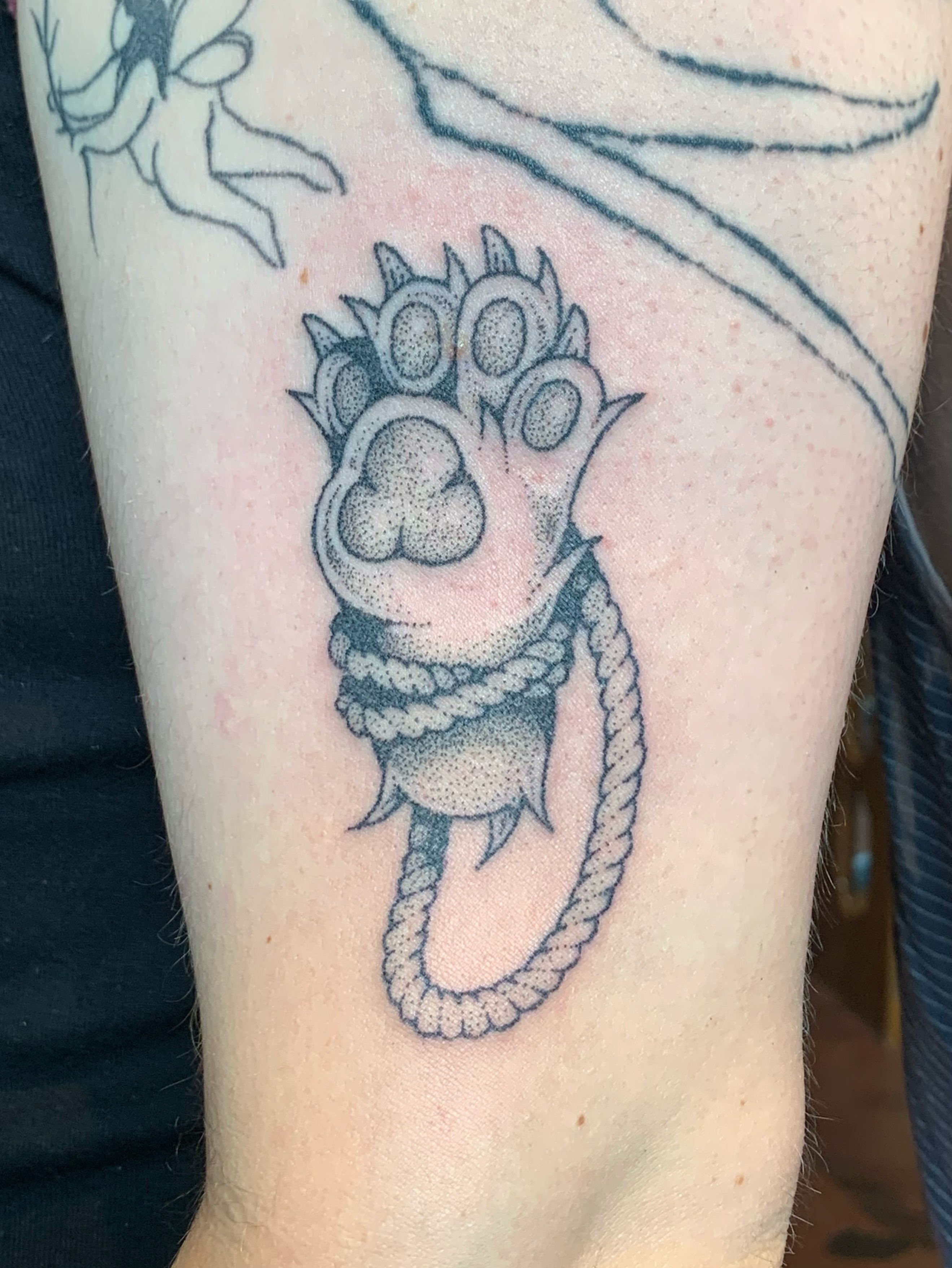 Bear paw with rope dotwork tattoo on the forearm by Lex Lloyd