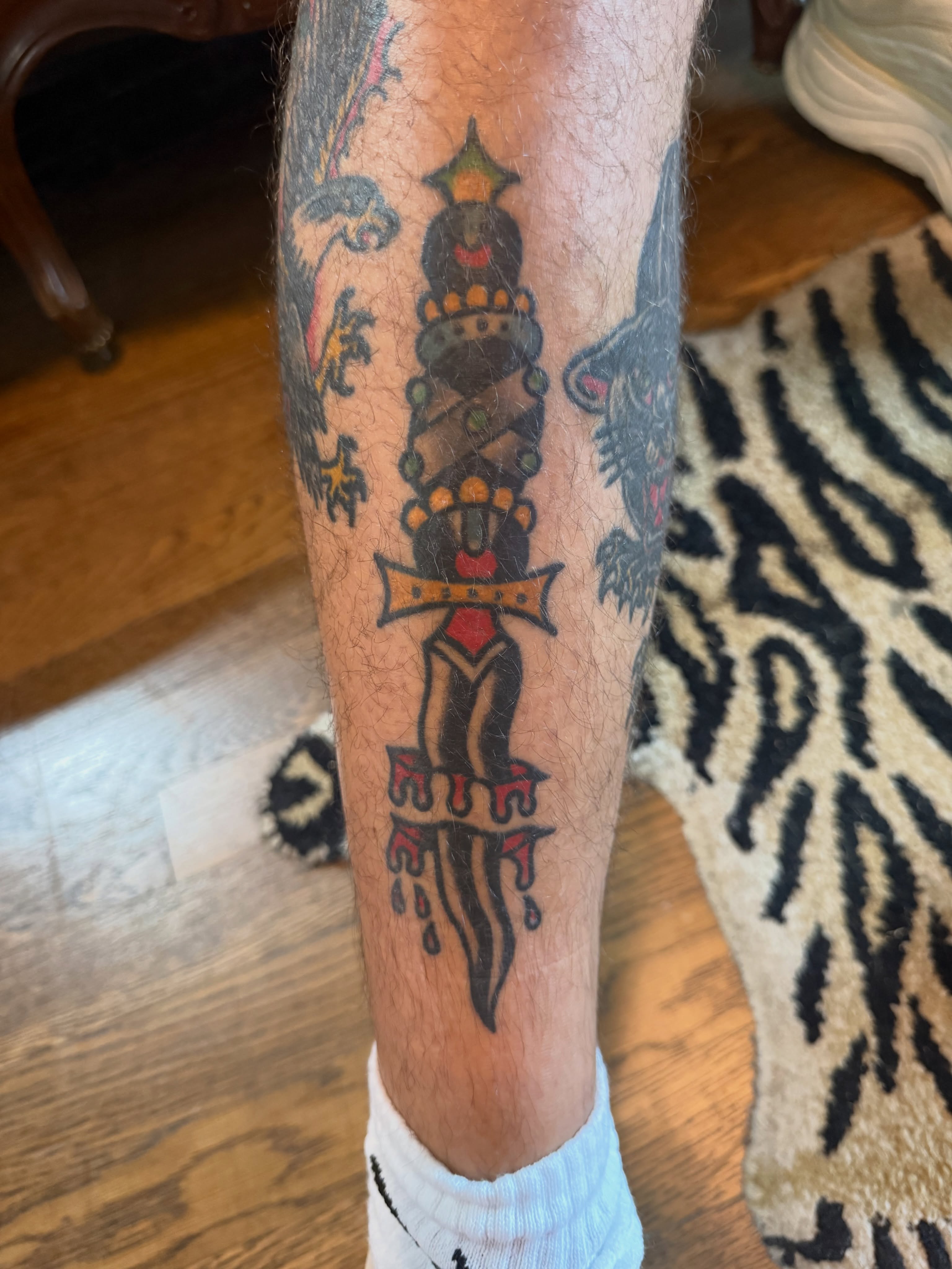 Sword with ornate hilt American traditional tattoo on the leg by Chuck Derek Whitaker