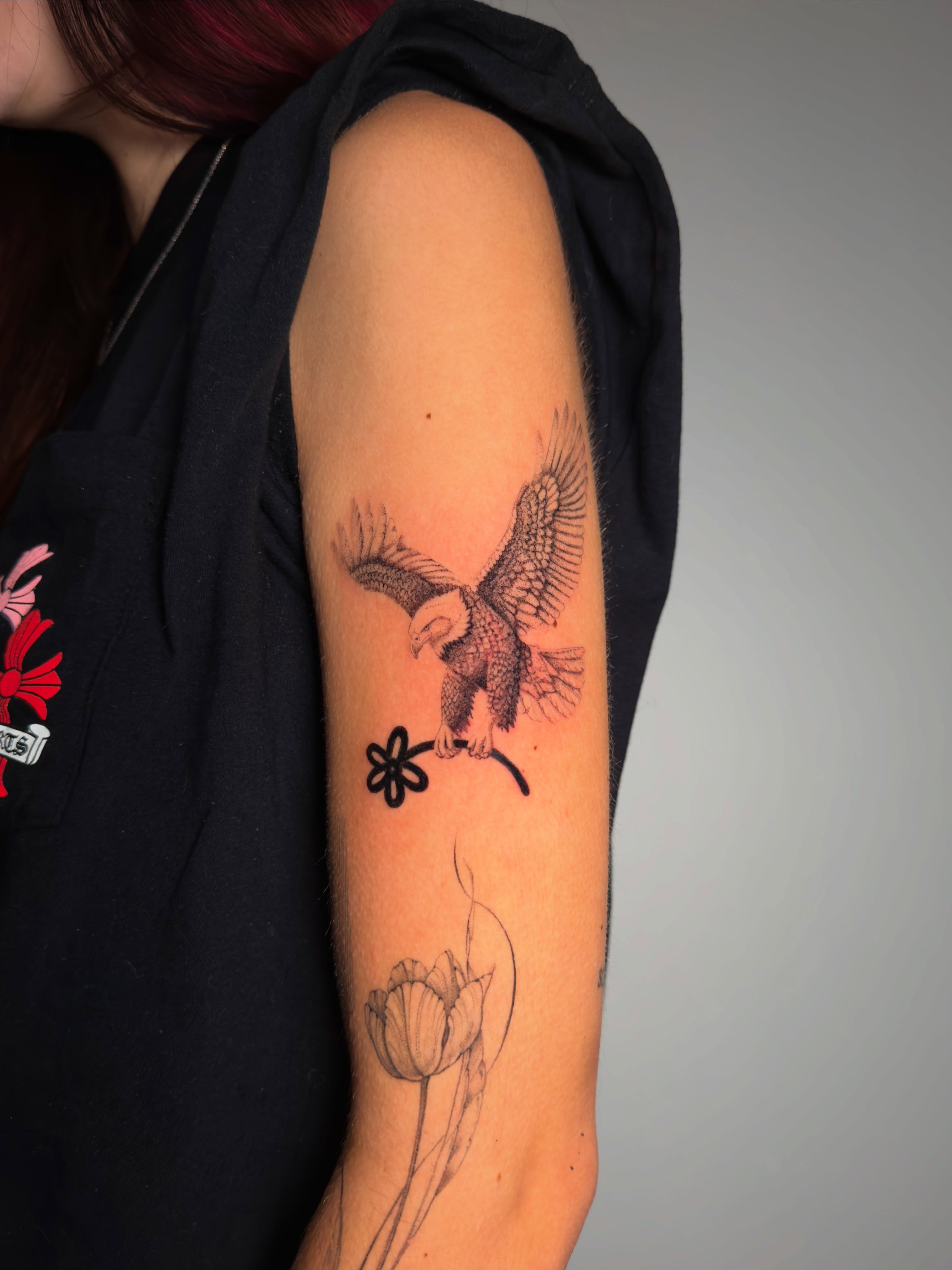 Eagle and flowers black and grey tattoo on the forearm by Piero Nuñez